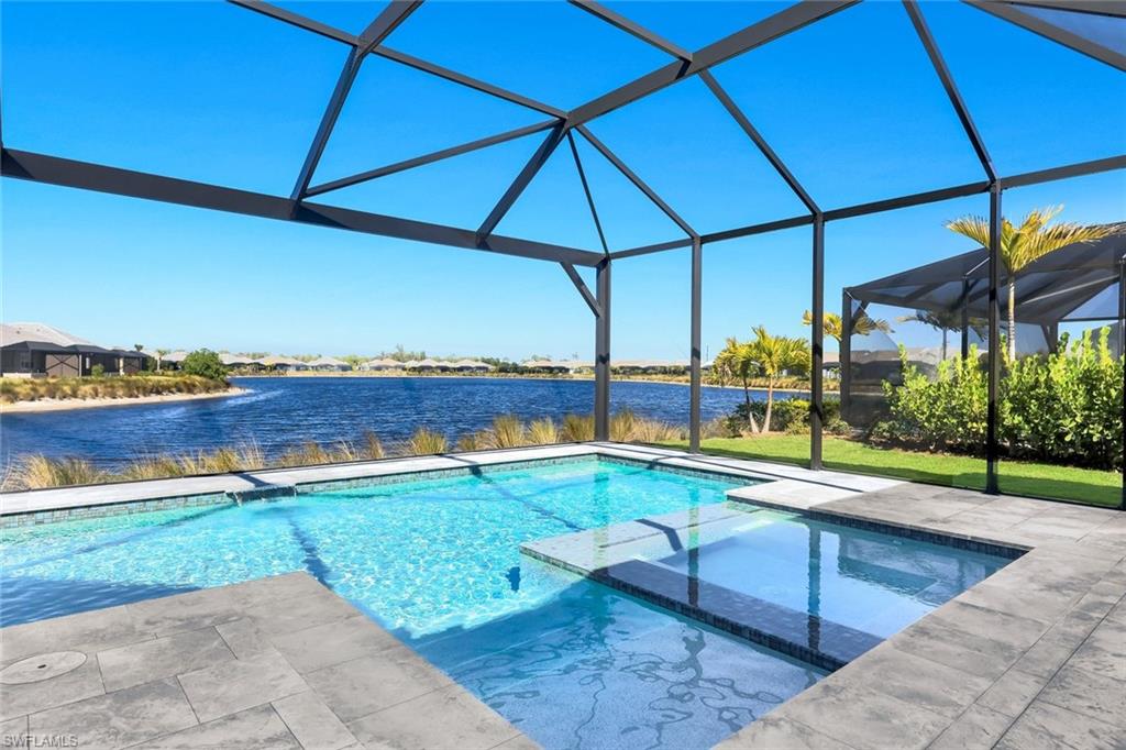 This HIGHLY UPGRADED New ACACIA Model Showcases Refined Designer Finishes and Modern Sophistication Throughout. Nicely Positioned on a Tranquil, Long Lake within the Prestigious ISLES OF COLLIER PRESERVE Community, This Exceptional Residence is Located Less Than 10 Minutes from DOWNTOWN Naples and the Iconic Fifth Avenue South.
Offered FULLY FURNISHED with High-End Furnishings, the Home Features 2,702 square feet of Impeccably Designed Living Space, Including Three Bedrooms Plus a Den and Three-and-a-Half Baths. A Grand Two-Story Foyer Welcomes you Into a Bright, Open-Concept Layout, a Striking STATEMENT WALLS and Thoughtfully Designed for Modern Living.The Chef’s Kitchen is a True Showpiece, appointed with TOP-OF-THE-LINE FISHER & PAYKEL APPLIANCES, Sleek Modern Cabinetry, and an Impressive LONG QUARTZ KITCHEN ISLAND, ideal for entertaining and everyday luxury living. Seamless Indoor-Outdoor Living Leads to a CUSTOM-DESIGNED HEATED SALT WATER MODERN POOL AND SPA Complemented by a MARBLE LANAI.This Nearly New Home offers peace of mind with HURRICANE-IMPACT WINDOWS and DOORS THROUGHOUT, Custom Walking Closet and Closet Systems, Highest Level Tile Flooring Throughout, Custom Outdoor Kitchen.Thoughtful Craftsmanship and Premium Construction. Set within the Resort-Style Isles of Collier Preserve Community, residents enjoy an unparalleled lifestyle featuring a private waterfront restaurant, resort-style and lap pools, 14 pickleball courts, tennis and bocce courts, a state-of-the-art fitness center, kayaking along the Cypress Waterway, miles of scenic walking and biking paths, and a dog park. PRIME Naples LOCATION —just minutes from world-class dining, upscale shopping, pristine beaches, the Bayshore Arts District, Naples Botanical Gardens, Hamilton Harbor Yacht Club, and the new $72 million Gulfshore Playhouse.