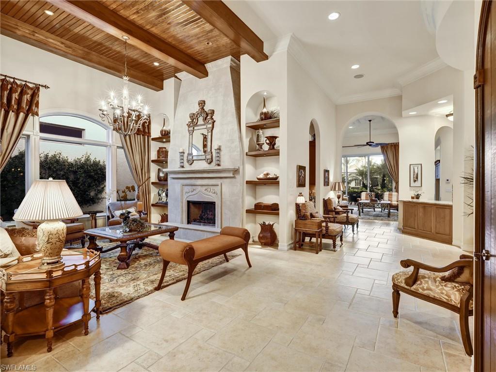 This exquisite, fully furnished home blends timeless sophistication with everyday comfort. From the moment you step inside, you’ll be greeted by soaring ceilings, custom details, and an inviting open flow. The living room features a beautiful stone fireplace and a sleek wet bar—perfect for entertaining. A 500+ bottle, temperature-controlled wine room elevates every gathering. The gourmet kitchen features a classic stone backsplash, a designer hood, and ample storage.

Two ensuite guest rooms and a private owner’s suite provide space and serenity. The main suite includes a luxurious bath, vanity, dressing area, and three closets. Outside, the expansive lakefront lanai sets the stage for relaxed living, complete with multiple seating and dining areas, a fireplace, a summer kitchen, and a sparkling pool and spa framed by peaceful fountains.

Immaculate, elegant, and move-in ready—this home is an exceptional opportunity to enjoy Naples living at its finest.