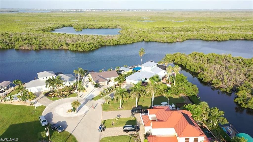 Experience coastal living at its finest with this exceptional Pine Island residence, designed for those who relish both nautical adventure and quiet luxury. Situated on a prime Gulf-access canal, the property allows you to step directly from your backyard, lower your boat lift, and be cruising in open waters within minutes. Panoramic views across the water greet you at every turn, serving as a breathtaking backdrop whether you’re relaxing poolside or entertaining guests on the expansive screened lanai. Inside, the home showcases generous living spaces, including a kitchen with abundant counter space and extensive cabinetry. This kitchen is perfect for culinary enthusiasts and host alike. Enjoy casual meals in the informal dining area or elevate your gatherings in the formal dining room with pool and water views. Retreat to one of four well-appointed bedrooms, including two Master Bedrooms each featuring walk-in closets and en suite baths. These bedrooms are spacious and perfect for accommodating family or guests in comfort and privacy. A long driveway provides ample parking for residents and visitors. Nature lovers will appreciate the mature fruit trees gracing the property, including dragon fruit, sugar apple, a bountiful mango tree, and a flourishing avocado tree. This residence combines the relaxed charm of island life with the elevated finishes and thoughtful design you would expect in a luxury waterfront home, an experience best appreciated in person.
***Home never flooded from storm surge***