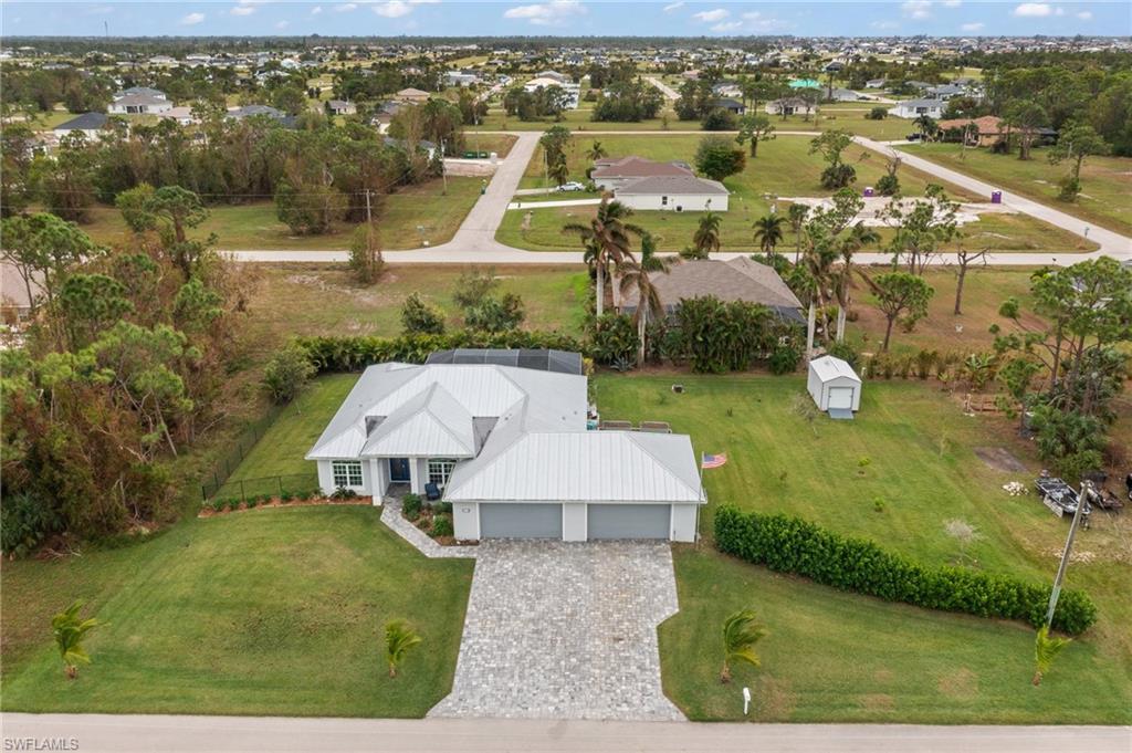 RARE FIND! Space, Luxury & Functionality in One Exceptional Home!

Business owners, car enthusiasts, hobbyists, or anyone simply looking for room to spread out, this unique property is designed to accommodate the way you live, work, and play. Situated on nearly half-acre lot, this newer-construction home combines modern luxury with an incredible amount of usable space, making it a rare find in Cape Coral.

One of the home's standout features is the true 4-car garage, offering abundant room for vehicles, motorcycles, workshop, tools, recreational equipment, storage, or a home-based business. Whether you need space for your collection, a dedicated hobby area, or simply want more room than the typical garage provides, this property delivers.

Inside, you'll find 4 bedrooms and 3 full bathrooms, with beautiful tile flooring throughout and custom tile work in the bathrooms. A secondary guest bedroom features its own en-suite pool bath, creating an ideal junior primary suite or private space for extended family.

The open-concept living area is designed for both everyday living and entertaining. The chef-inspired kitchen features two full-size wall ovens, a built-in pantry, generous counter space, and plenty of room for meal prep. The open layout flows naturally into the living room, while the formal dining area provides the perfect setting for holiday gatherings, dinner parties, and entertaining.

Step outside and enjoy your own private retreat. A Southern exposure sparkling pool provides the perfect place to relax, entertain, and enjoy the Florida lifestyle throughout the year. The fenced backyard offers privacy and flexibility, while a mature Areca Palm hedge creates a natural privacy screen.

For those who appreciate efficiency, durability, and thoughtful upgrades, this home offers several notable features, including impact windows and doors, spray foam insulation, a heat pump water heater, mini split in the garage space, and a whole-house reverse osmosis system providing filtered water throughout the home.

The outdoor space is equally functional, with a large gardening area, built-in planters, and a newer shed that conveys with the property. Whether you enjoy gardening, DIY projects, outdoor hobbies, or simply want additional storage, there's room to make the space your own.

With convenient access to US 41, I-75, Pine Island Road, and Veterans Parkway, it's easy to reach shopping, dining, entertainment, neighboring communities, and everything Cape Coral and SW Florida have to offer.

With its combination of nearly half an acre, a true 4-car garage, pool, flexible living spaces, extensive upgrades, and incredible indoor/outdoor functionality, this is far more than just another home, it's a property designed to give you room to live the Florida lifestyle your way.

If you've been searching for a home that offers space, versatility, privacy, and features you simply don't find every day, this one deserves a closer look.