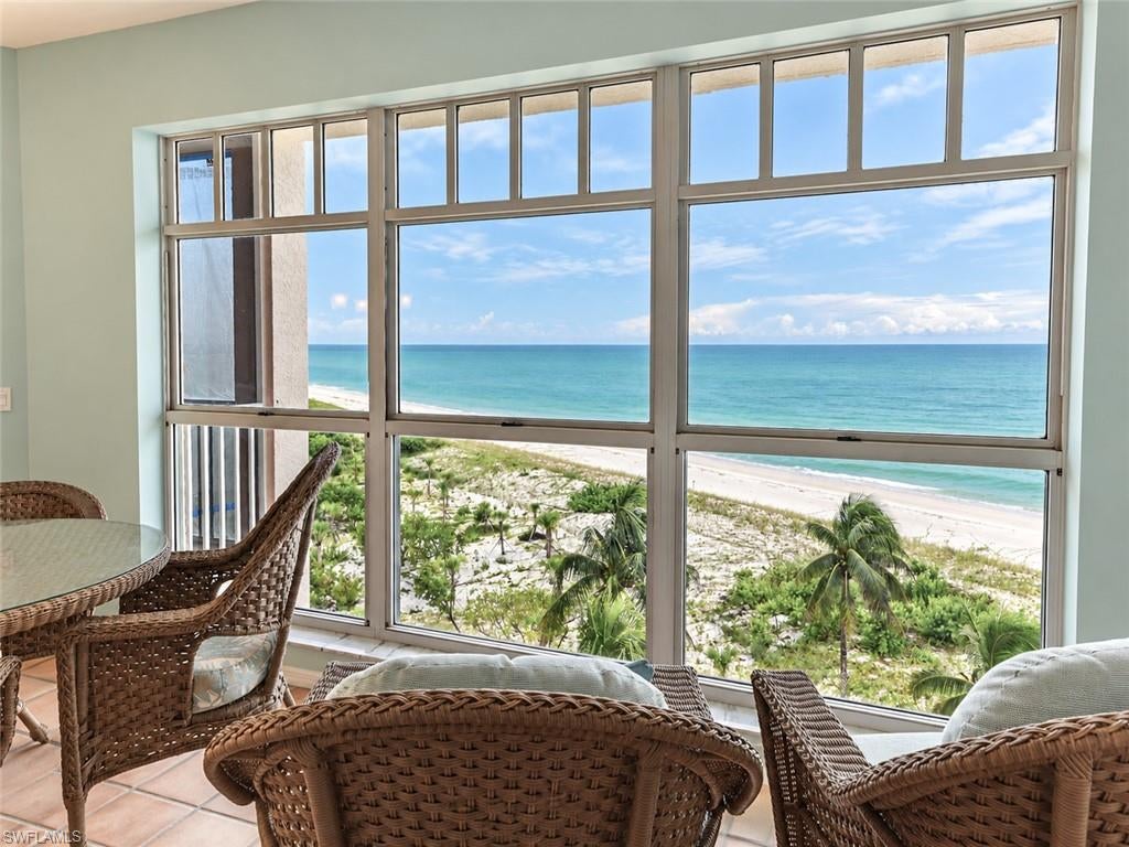 This 3 bedroom Barefoot Beach Condo offers the Ultimate Beachfront living: Wide Gulf views from kitchen, dining, great room & master bedroom, Building 263 has completed restoration updates including new outdoor deck, screen enclosure, railings, new outdoor lanai tile & new 2026 code electric shutters (to be installed soon)  an included clubhouse with 2 story fitness right on the beach plus swimming pool plus a new swimming pool to be constructed at building 263, A CLUB AT BAREFOOT BEACH MEMBERSHIP AVAILABLE IMMEDIATELY AT CLOSING (THERE IS NO AVAILABILITY CURRENTLY - AVOID THE MULTI YEAR WAITLIST WHEN MEMBERSHIPS ARE REOPENED) - RESORT STYLE AMENITIES INCLUDING: FINE AND CASUAL DINING,  DRINKS AND DINING AT THE POOL AND BEACH, FULL BEACH SERVICES, INDOOR OUTDOOR BAR, ICE CREAM SHOP, TENNIS, AND A VIBRANT SOCIAL CALENDAR WITH OUTSTANDING CONTINUAL EVENTS, gated entrance with 2 guards 24 hours 7 days per week, Royal palm lined brink pavered street, an available boat dock to lease, under building parking, and this well kept condo is offered turnkey furnished for easy move in at closing.  You will experience the extraordinary beauty of Gulf-front living in this spacious 3-bedroom condominium, ideally situated within the prestigious, private gated beachfront community of Barefoot Beach. Offering breathtaking panoramic views of the Gulf of America, miles of pristine white sand beaches, and spectacular sunsets, this exceptional residence provides an outstanding opportunity to enjoy one of Southwest Florida's most desirable coastal destinations. Designed to capture the beauty of its remarkable beachfront setting, the residence features an inviting open floor plan, abundant natural light, and expansive windows framing the turquoise waters of the Gulf. Classic Saltillo tile flooring creates a warm coastal atmosphere throughout the main living areas, complemented by soft tropical colors and comfortable living spaces. The well-appointed kitchen features beautiful wood cabinetry, generous counter space, a convenient breakfast bar, and an adjoining casual dining area. Its open design allows for easy interaction with the main living spaces while maintaining a comfortable and functional layout. .The generous master suite serves as a peaceful waterfront retreat, featuring beautiful Gulf views, direct access to the screened lanai, and a spacious private bath complete with dual vanities, a soaking tub, and a separate glass-enclosed shower. Two additional bedrooms offer comfortable accommodations for guests or family members, providing flexibility and privacy.One of the residence's most captivating features is the expansive screened lanai, where uninterrupted Gulf views, refreshing sea breezes, and the soothing sounds of the surf create an extraordinary outdoor living experience. Enjoy morning coffee overlooking the sparkling turquoise water, afternoon relaxation, or unforgettable sunsets as the sky transforms over the horizon.