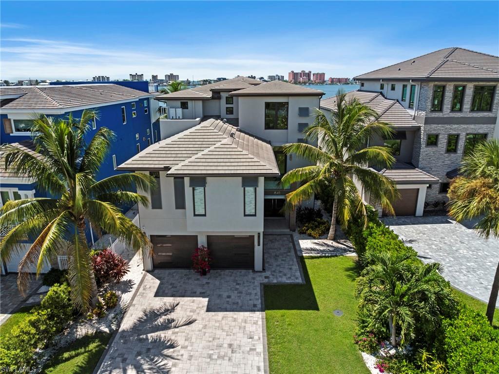 A rare waterfront masterpiece, this spectacular custom bayfront residence delivers breathtaking panoramic views, direct Gulf access, and an extraordinary level of luxury—offering the ultimate Southwest Florida waterfront lifestyle. Designed to capture the beauty of its spectacular setting, this 4-bedroom, 4 full and 2 half-bath home combines sophisticated design with incredible indoor/outdoor living. The light filled open floor plan showcases soaring ceilings, oversized tile and hardwood flooring, a dramatic custom glass staircase and walls of glass framing panoramic water views. The gourmet kitchen is a showpiece with premium Viking appliances, built-in coffee maker, expansive island and abundant space for entertaining. The luxurious primary suite features its own private balcony overlooking the bay and an impressive spa-inspired bath. Outside is where the Florida lifestyle truly shines! Enjoy a resort-style pool and spa, expansive outdoor living area with built-in bar and grill, and spectacular sunset views across the water. A newly added artificial-turf putting green sits directly along the seawall, creating an incredible waterfront setting to practice your short game. Boaters will appreciate direct Gulf access and an impressive dock featuring a 32,000-lb platform boat lift plus an additional lift for another boat or water toys. Additional upgrades include a whole-house generator and flood barrier protection for added peace of mind. And for something truly extraordinary—this home even features its own private indoor pickleball court! Elevator in foyer for those that wish to skip the stairs! Ideally located near Fort Myers Beach, this one-of-a-kind bayfront residence delivers the complete Southwest Florida lifestyle—luxury, boating, entertaining, recreation and unforgettable waterfront sunsets, all from your own private paradise.