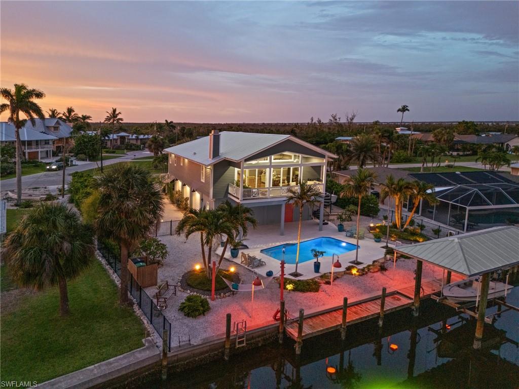 Welcome to your private island retreat in the heart of St. James City, where your backyard opens to a true protected preserve alive with Southwest Florida wildlife. Watch manatees and dolphins, cast a line from your own waterfront, and enjoy birds and native wildlife in a peaceful natural setting that feels worlds away—yet offers exceptional boating access to everything Pine Island is known for. Set on an oversized lot, this distinctive home was designed for both everyday comfort and entertaining, offering two spacious primary suites, each with a private en suite, an open-concept great room with beautiful Brazilian Cherrywood floors and a striking Key Largo limestone fireplace, and walls of glass sliders that open to the expansive lanai and incredible preserve views beyond. At the heart of the home, the chef’s kitchen features custom wood cabinetry, quartz countertops, tile backsplash, GE Profile appliances and a generous center island, complemented by a separate wet bar perfect for entertaining. Step outside to your own tropical waterfront oasis featuring a sparkling pool with desirable southern exposure and a private tiki hut—the perfect place for cocktails, casual gatherings or simply relaxing while watching nature unfold along the preserve. Boaters will appreciate the boat lift and direct, deep-water Gulf access, putting Pine Island Sound and the renowned fishing, boating and beaches of Sanibel, Captiva, Cayo Costa and Fort Myers Beach within easy reach. One of the property’s standout features is the impressive 60' x 32' three-car garage with 10' ceilings, extended workshop area, air compressor with ceiling-mounted air reel and a convenient half bath that also serves the pool area. Additional features include RV parking with 50-amp service, impact windows and doors, Hardie Board siding, automated interior and exterior lighting, landscape lighting and a new roof in 2023. Even better, the assumable flood insurance is only $1,764 per year. Surrounded by protected natural beauty with incredible wildlife right outside your door, this is more than a waterfront home—it’s an opportunity to experience the boating, fishing, nature and laid-back island lifestyle that makes St. James City so special.