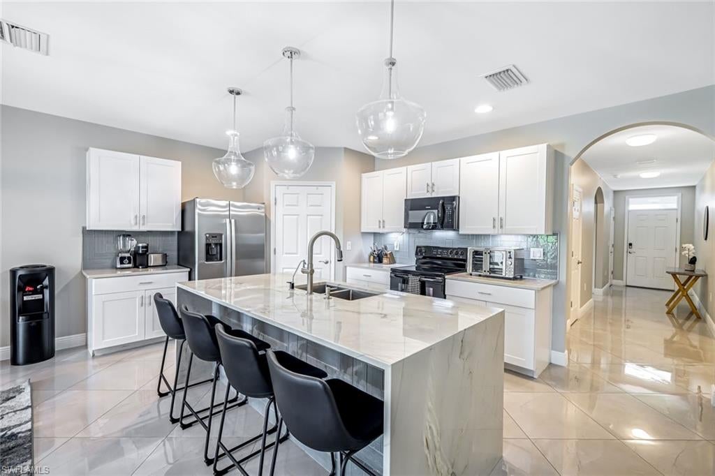Move-In Ready SMART Home with High-End Finishes, New Landscaping & Prime Location! This beautifully upgraded 4-bedroom, 2-bath, 2-car garage SMART home offers 1,828 sq. ft. of open-concept living in a centrally located neighborhood—just minutes from Florida Gulf Coast University (FGCU), I-75, and Southwest Florida's top beach communities. Built in 2019 by DR Horton, this home blends modern design, comfort, and functionality. Interior Features Include: Quartzite natural stone countertops & stunning waterfall kitchen island, Tile backsplash & custom lighting throughout, Wood style flooring in all bedrooms; oversized tile in main living areas, SMART home technology for added convenience and energy efficiency, The owner’s suite is a serene retreat featuring a walk-in closet and a spa-style en-suite bathroom with a glass-enclosed tile shower, dual shower heads, double vanities, and a backlit mirror. The flexible floor plan has been modified to adjoin the 4th bedroom with access to the primary bath—creating the perfect use as not only a 4th bedroom but also as a home office, nursery, or private den. A true split layout offers two additional bedrooms and a spacious shared bath on the opposite side of the home. Step outside to your fully fenced backyard, complete with new professional landscaping, a covered lanai, paver patio, and plenty of space to add a future pool. The expanded pavered driveway offers ample room for guest or multi-vehicle parking. Additional highlights include a Whole-house water treatment & filtration system, Separate laundry room, Move-in ready condition—no updates needed! Conveniently located near RSW Airport, Miromar Outlets, shopping, dining, and beautiful Gulf beaches, this home is perfect for full-time living, seasonal getaways, or investment potential.
