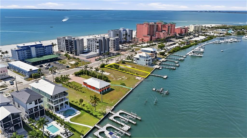 One or more photo(s) has been virtually staged, AI generated or rendered.  Premier Bayfront Homesite | High-Performance Vacation Rental Opportunity Exceptional opportunity to build a luxury income-producing vacation rental property on this prime bayfront homesite overlooking Estero Bay, ideally located on the highly desirable north end of Fort Myers Beach. This rare 8,525± sq ft lot (50’ x 160’) offers the potential to design an elevated luxury residence with panoramic bay views and Gulf views just across the street, creating the ultimate beach-to-bay rental destination. Perfectly positioned for the vacation market, this property offers direct boating access to Estero Bay and the Gulf of Mexico, with boating routes to Sanibel, Boca Grande, Cabbage Key, and numerous waterfront restaurants throughout Southwest Florida. The location is highly attractive to vacation guests seeking boating, beach access, and walkable island entertainment. Design a large luxury rental residence featuring multiple bedrooms, expansive outdoor living areas, rooftop or balcony viewing decks, and a resort-style pool and spa overlooking the bay. The lot offers space for outdoor entertainment areas, a private dock, and sunset-view terraces—features that significantly increase rental demand and nightly rates. An assemblage opportunity is also available with the adjacent lot at 385 Estero, creating potential for an even larger luxury rental compound or estate-sized development. Just a short walk along the beach to Times Square, the Pier District, Margaritaville, and dozens of restaurants, shops, and entertainment venues, this location consistently attracts visitors seeking the best of Fort Myers Beach. A rare investment opportunity to develop a premier waterfront vacation rental property in one of the island’s most desirable and walkable locations. Multiple Builder introductions available.