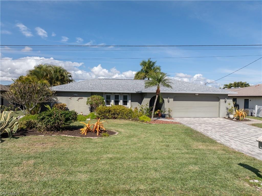 Enjoy SW Florida living at its best! Don’t miss this fully furnished, turnkey, Gulf-access opportunity in SE Cape Coral—all furniture is included. Flood insurance is NOT required; the seller has received a LOMA Exemption Letter. This move-in-ready 3BR/2BA home offers 1,800 sq ft of open-concept living with vaulted ceilings and effortless indoor-outdoor flow.  Boater’s setup: one-bridge Gulf access, dock with electric, and 10,000-lb boat lift with canopy. Bonus: 3 kayaks included! Major upgrades done: NEW Roof (2022), HVAC (2023), 11 triple-pane windows (2019), stainless dishwasher/microwave (2025), and refrigerator (2023).  Kitchen features a granite island and ample workspace. LVP flooring throughout. Relax in your private tropical retreat featuring a beautifully refinished pool (2026) and a hot tub. Surrounded by peaceful landscaping with a flowering trellis-lined walkway to the water. Turnkey and priced to move—schedule your showing today!