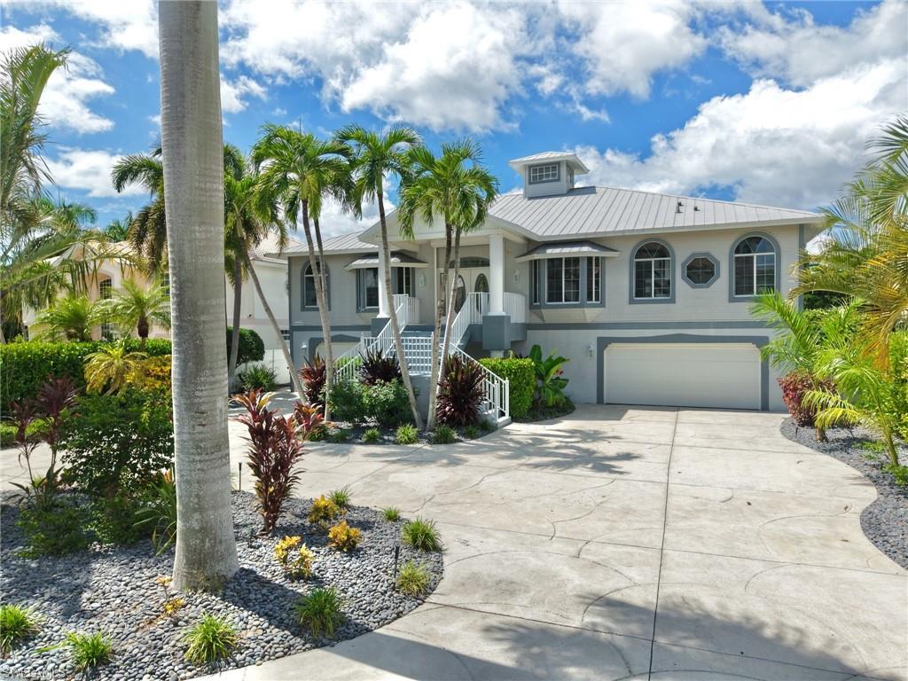 Some photos are Virtual Stagged. Discover waterfront living in the gated boating community of Palm Isles! This community is located just 2 miles from Fort Myers Beach.  This spacious two-story has 5 Bedrooms and 4 1/2 Baths with direct Gulf access and no bridges. Designed for both everyday comfort and entertaining, the home features soaring ceilings, a generous great room, formal dining area, wet bar, and an abundance of natural light throughout. The kitchen offers ample cabinetry, a breakfast bar, and a separate breakfast area. The primary suite features dual sinks, a separate soaking tub, a walk-in shower, and a spacious closet. The lower level has a sports bar, 2 bedrooms, and a full bath with a soaking tub and separate shower. Step outside to your private screened pool and lanai, surrounded by tropical landscaping and overlooking the peaceful canal. Boating enthusiasts will appreciate the 65' dock with available electric and water, which can support one or 2 lifts. Direct access to the Gulf. Situated on an approximately quarter-acre waterfront lot with low annual HOA fees, this property presents a wonderful opportunity to enjoy the Southwest Florida boating lifestyle, just minutes from the beaches, dining, shopping, and entertainment of Fort Myers Beach and Sanibel, either by boat or car.