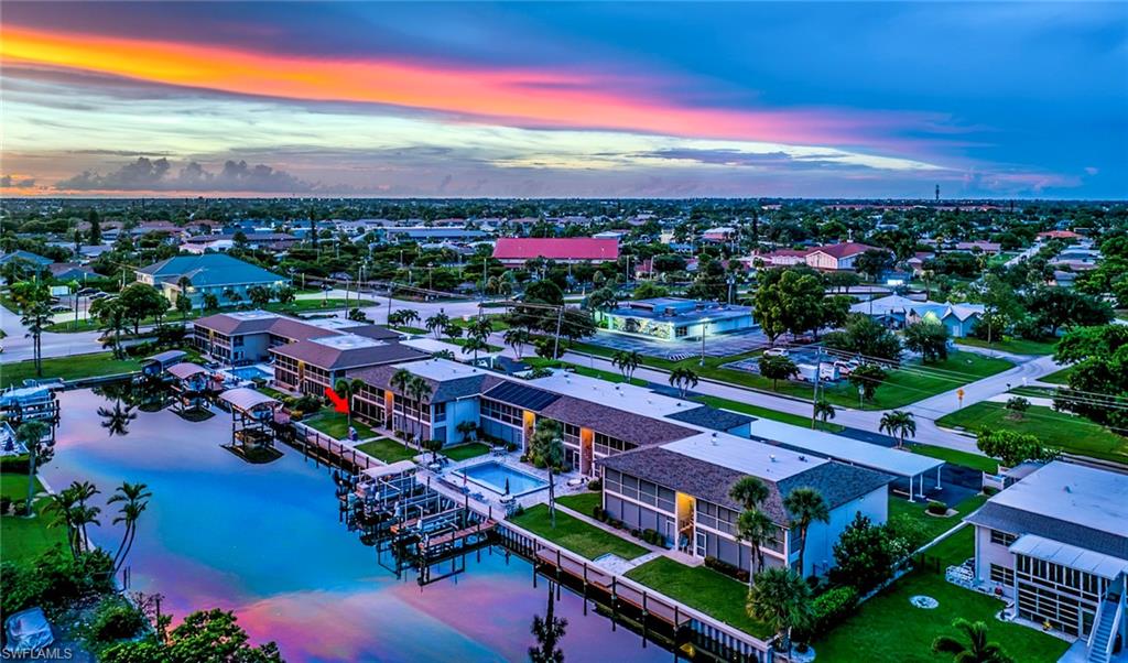 BOATER'S DREAM — DEEDED BOAT SLIP + 9,000-LB LIFT INCLUDED! Enjoy the best of the Southwest Florida waterfront lifestyle from this fully furnished, first-floor end-unit condo, where your boat is just steps from your screened lanai. The deeded private boat slip and 9,000-lb lift accommodate up to a 25-foot boat, making this an exceptional opportunity for boaters who want convenience without the maintenance and expense of a single-family waterfront home. Inside, you'll find a bright, open-concept layout with a neutral coastal palette, tile flooring throughout the main living areas, and a well-maintained, move-in-ready interior. The screened lanai overlooks the waterfront and is ideally positioned near the community pool — the perfect place to enjoy morning coffee, watch the boats go by, or unwind after a day on the water. Recent condo updates include a new HVAC (2025), new front door (2025), new bedroom carpet (2023). The community has also completed significant improvements, giving the next owner peace of mind: pool and deck renovation (2026), seawall and dock improvements (2025), exterior painting (2024), new carports (2024), new roofs (2023), and electrical meters/breaker boxes (2019). An additional exterior storage shed is provided for each unit. No upcoming assessments. And when you're ready to leave the water, you're within walking distance of Downtown Cape Coral for restaurants, coffee, shopping and nightlife. Whether you're looking for a full-time Florida residence, a seasonal getaway, or a low-maintenance waterfront retreat with boating right outside your door, this is the Florida boating lifestyle without the price, upkeep and responsibilities of a single-family waterfront home. Bring the boat, your bathing suit and flip-flops. You're home! This is a 55+ community.