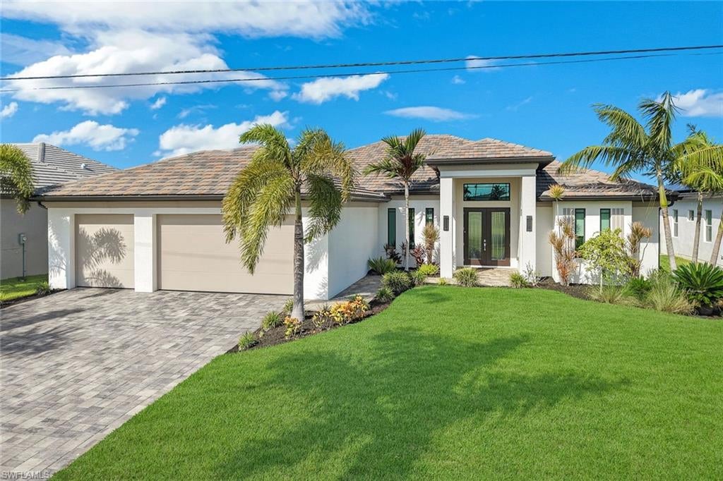 Experience the pinnacle of Southwest Florida waterfront living in this stunning, CUSTOM-BUILT 2472 SQ FT RESIDENCE BY AWARD-WINNING BUILDER TUNDRA HOMES, situated on a PRIME GULF-ACCESS CANAL with desirable WESTERN REAR EXPOSURE in Northwest Cape Coral. Offering an expansive layout, this luxury residence features 4 BEDROOMS, 3 BATHROOMS, DEDICATED HOME OFFICE, AND A 3-CAR GARAGE (30'x22') finished with an epoxy floor. Inside, you are welcomed by volume ceilings with cypress beams in great room, sleek 24-inch tile flooring throughout, impact glass doors and windows with custom electric coverings, designer lighting, built-in audio speakers, and a whole-house reverse osmosis water system. The kitchen is a chef's dream, complete with premium Cambria countertops, elegant tile backsplash with pot-filler, wood cabinetry, a walk-in pantry with barn-door entry, and a stainless steel Thermador appliance package. Designed for seamless entertaining, the interior flows effortlessly through 10' 90° sliding glass doors out to the incredible outdoor living space, which highlights a cypress ceiling, outdoor kitchen including grill & side burner, cozy gas fireplace, and electric roll-down hurricane screens on the lanai for ultimate protection and comfort. Under the Florida sun, you'll find your private resort complete with a saltwater pool and spa with luxurious shell stone travertine pool deck, and a screened-in pool cage. For the boating enthusiast, the property features a tall seawall ('21), a private boat dock with a lift (10k lbs), low-maintenance composite decking, and a charming tiki hut on the dock. Finished with a tile roof, gutters all the way around perimeter, privacy fence, paver driveway, floritam sod and irrigation system, beautiful landscaping with lighting, and exceptional architectural craftsmanship.  This extraordinary home delivers the ultimate Florida lifestyle!