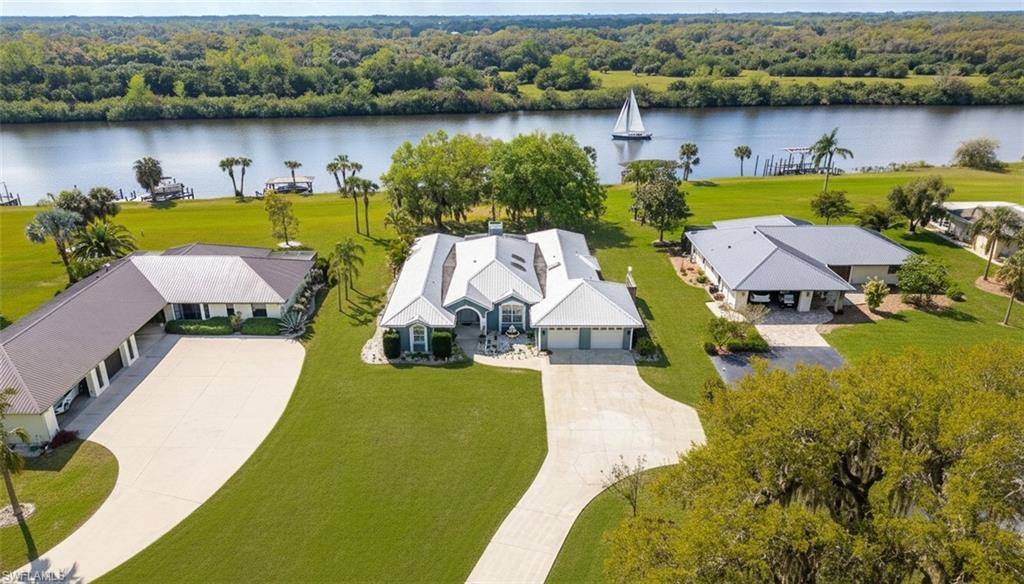 Experience fantastic waterfront living in Riverbend Estates, one of LaBelle’s premier communities. This beautiful home sits directly on the Caloosahatchee River (Intracoastal Waterway) and includes a private deep-water dock with direct access to the Gulf, Lake Okeechobee, and the Atlantic Ocean.

Inside, an open, light-filled layout features hardwood floors, a fireplace, and sweeping river views. The remodeled kitchen showcases quartz countertops, stainless steel appliances, and modern finishes. The primary suite serves as a private retreat with dual vanities, a soaking tub, a walk-in tile shower with dual shower heads, and an oversized walk-in closet.

A screened lanai overlooks the river, creating the perfect spot to unwind and watch boats pass by. Whether you’re into boating, fishing, or waterfront relaxation, this property makes it effortless.

Riverbend Estates offers resort-style amenities—community pool, clubhouse, and recreation center—with a low $330/month HOA covering water, sewer, lawn care, irrigation, and full access to community facilities.

Waterfront opportunities like this are rare in LaBelle. Claim your slice of paradise on the river.