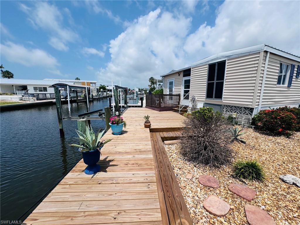 2-Bed/2-Bath water front home with DIRECT GULF ACCESS, NO BRIDGES OR LIFT STATION!
 Beautiful south facing canal views! NEW DOCK WITH electric BOAT LIFT. Enjoy the dolphins, manatees and fishing right outside your door. The open floor plan allows for great entertaining space inside and out! . COMPLETE REMODEL!stainless appliances, soft close kitchen cabinets, stone surfaces and pantry. New drywall, insulation, electric and 3 mini split AC , subfloor, vinyl plank flooring, cabinets with stone surfaces and stone vanities, new showers and toilets. Large florida room with laundry and strorage. The deep carport parks 2+ vehicles. . Bayside Estates is a highly desirable community with community pool, tennis, pickle ball, horse shoes, bocce ball, community room and library. Enjoy boating to Ft. Myers Beach, Sanibel and all of the local restaurants and beaches right from your dock. Drive minutes to beaches, restaurants shopping and more! 55+ community. Community offers pickle ball, tennis, shuffle board, pool, work out facility, library, club house, horseshoes, community parties, cards, and tons of social events. Owner open to rental options. Transferable flood insurance.