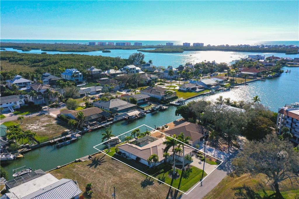This completely refashioned Collier County waterfront home is the perfect blend of luxury, location, and lifestyle, a Boaters’ dream! This stunning furnished home features a completely refashioned designer furnished interior and exterior. The designer-renovated interior boasts tile floors throughout, designer lighting and ceilings fans, and custom window treatments. The chef’s kitchen is a showstopper with custom cabinetry, quartz counters, custom backsplash, stainless steel appliances, and a large island with seating. The spacious master suite offers a custom designed bath with a large shower and finished walk in closet. Step outside to your private lanai that connects the pool area to the waterfront. Enjoy 2 boat lifts (#8500) up to 24’ and (#13,500) up to 35’ direct Gulf access with no bridges. NO HOA restrictions! The attached guest house is perfect for extended family and friends. This home is complete with a (2024) HVAC, (2024) tile roof and electric storm shutters. Located in the sought-after Little Hickory Shores boating community, this home is just minutes from Barefoot Beach, shopping, restaurants, grocery stores, fitness centers, and beautiful white sandy beaches. Whether you prefer to walk, bike, or boat, this is paradise.