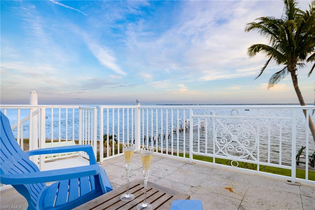 With unobstructed views of the bay, perfectly framed by the tropical landscape, this residence embodies the essence of waterfront living. Upon entering the main level, you will be greeted by an abundance of natural light and vistas complimenting the fireplace in a harmonious blend of coastal and classic design. Entertain family and friends in the formal dining area or the main level balconies overlooking your backyard as dolphins swim in the background. The kitchen boasts views of the bay and offers plenty of cabinet and counterspace, a gas range and a wet bar that connects the kitchen to the family room. The primary quarters offer two walk in closets and a spacious bedroom surrounded by mature landscaping that integrates with the natural beauty of the surroundings. The well appointed guest bedrooms, one on the main level and the other on the first floor, award your guests with privacy. On the first floor you'll find a separate sitting room, a den (which the owners used as an exercise room) and a laundry room with an extra refrigerator and sink. From the office and recreation rooms you can step outside onto the expansive patio, where the beauty of coastal living truly comes to life. Sip cocktails as you watch boats glide across the bay, or indulge in alfresco dining under the pergola covered in blooming flowers. This waterfront setting offers endless opportunities for outdoor recreation, from kayaking and paddleboarding to fishing and birdwatching. The boating community of St. James City is conveniently located a short boat ride away from the Sanibel Causeway and beaches to the south and to the north, through Pine Island Sound, to the world famous Cabbage Key, Useppa Island, and Boca Grande pass. Whether appreciating some of the most pristine natural habitats in SWFL, sport fishing for tarpon or bar hoping by water, the options are endless