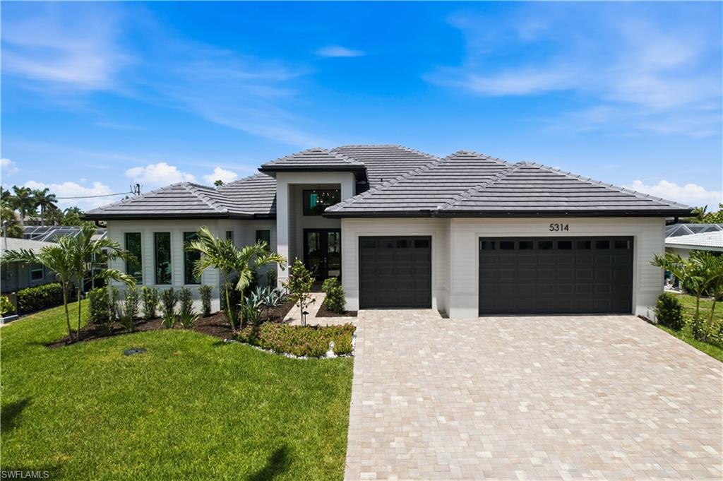 Introducing an exceptional new-construction waterfront residence in Cape Coral’s highly desirable Yacht Club area, offering western rear exposure and direct, no-bridge route only minutes to the Caloosahatchee River and open Gulf waters. Designed for effortless Florida living and conveying furnished, the home offers approximately 2,780 square feet of air-conditioned living space and more than 4,000 total square feet, with four bedrooms plus a den/home office that could function as a 5th bedroom, four full bathrooms and an additional powder room. A dramatic double-height foyer opens to a light-filled great room featuring soaring ceilings, 90-degree corner sliding-glass doors, a striking porcelain fireplace feature wall, tall ceilings and refined designer finishes throughout. The indoor and outdoor living spaces connect seamlessly, creating an exceptional setting for entertaining while embracing the home’s spectacular waterfront setting. The gourmet kitchen showcases ceiling-height custom cabinetry with illuminated glass upper cabinets, quartz countertops, an oversized island, designer tile backsplash, walk-in pantry and premium stainless-steel appliances, including a gas cooktop (easily converted to induction), wall oven and built-in microwave. The luxurious owner’s suite offers a private retreat with spacious his-and-hers walk-in closets and a spa-inspired bath featuring dual vanities, a freestanding soaking tub and an expansive walk-in shower. The expansive screened lanai overlooks the canal and western sky. An infinity-edge heated pool with smart controls and integrated spa, two fire bowls and a fully equipped outdoor kitchen featuring a connected Blaze gas grill create a private resort-style setting for relaxing and entertaining while enjoying breathtaking sunset views. Additional features include upgraded landscaping, impact-resistant windows and doors, a reinforced five-course stem wall foundation for enhanced elevation, structural integrity and flood resilience, a premium concrete seawall with a reinforced concrete tie-back anchoring system, an underground 250 gallon propane tank, Level 5 smooth-finish walls, wood-look plank tile flooring, and a spacious three-car garage with durable epoxy flooring and insulated ceilings for improved comfort and energy efficiency. Located near waterfront dining, downtown Cape Coral and the Fort Myers riverfront, this newly built residence presents a rare opportunity to enjoy modern luxury, exceptional boating access and unforgettable Southwest Florida sunsets.