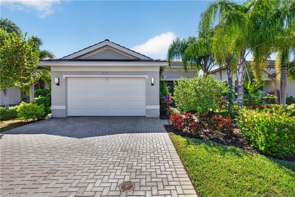 If you've been waiting for a beautifully upgraded Sierra with lakefront views and exceptional outdoor living — this is it! Move right into this upgraded 3-bedroom, 2-bath home featuring desirable southern exposure, an expansive screened lanai featuring a private, in-ground gas-heated spa. The screened entry and decorative etched-glass front door open into a room sized foyer and double-tray ceiling hallway accented with crown molding, creating a striking first impression. The open living and dining areas flow seamlessly to the spacious lanai, where peaceful lake views and a relaxing spa create the perfect setting for entertaining or unwinding. Motorized Storm Smart roll-down hurricane screens, along with impact-resistant windows and exterior doors, provide added protection and peace of mind. Inside, the kitchen features quartz countertops, a designer glass tile backsplash, an externally vented range hood, reverse osmosis water filtration, and a large walk-in pantry with added shelving. The primary suite offers an elegant coffered ceiling and two custom California Closets organization systems with a space saving pocket door on one. The upgraded primary bath showcases a frameless glass shower and oversized vanity mirrors extending to the ceiling w/ custom lighting. You'll LOVE the crown molding throughout this home. The 3rd BR/den features Art Deco-style glass French doors, adding character. The laundry room includes a pocket door, laundry tub, and cabinetry. Other upgrades include a tankless gas water heater, automated A/C condensate drain cleaning system, a garage featuring epoxy flooring, motorized overhead storage lift and a wall storage system. Offered partially furnished, this exceptional Sierra combines thoughtful upgrades, a floor plan which makes entertaining a breeze, all on a beautiful lakefront setting. Valencia Bonita lifestyle is unparalleled offering low HOA fees (Group bundled Xfinity cable and internet package just added to save residents $), no CDD, natural gas,  a 45,000 sq. ft. Clubhouse + Lifestyle Complex surrounded by 10 acres of world-class amenities. Enjoy tennis, pickleball, bocce, lap/resistance/grandkids and resort-style pools, fitness center, indoor/outdoor dining and bars, over 50 social clubs, firepits, cabanas, full service spa and nail salon, and even a pottery studio. With clubs for every interest – from Philanthropy, Adventure, Stitchers’, to BBQ, Bourbon and Corvette – you choose how active and social you want to be. Full time Lifestyle Director on premises selects entertainment year round! TOP NOTCH fitness program at reasonable cost with classes for all ability levels! This home is more than just another beautifyl home in FL; Valencia Bonita offers a 55+ coveted lifestyle. Move in and live the ultimate Florida dream. Just 20 minutes to the beach and less than 1/2 hr to RSW airport! This exceptional lakefront Sierra is ready to welcome you home!