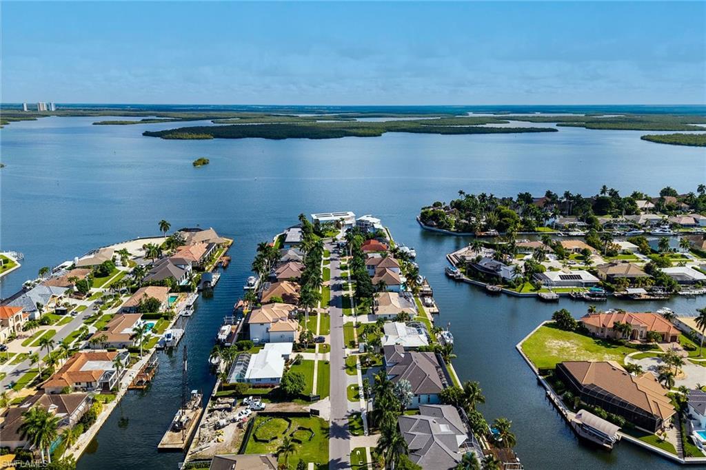 Welcome to 1763 Wavecrest Court, providing long open water views, southeast exposure and fantastic direct water access opportunity on Marco Island. Set on 100 feet of water frontage, this larger than average homesite has three bedrooms and three baths offering a practical way to enjoy Marco Island now while planning for the future. The home features comfortable living spaces, oversized bedrooms, updated kitchen, pocket sliders, boat dock with lift, large lanai, mature landscaping and a two-car garage with an epoxy floor, making it an ideal property to use, lease, or enjoy while waiting for permits and plans for a new home. With direct water access and a desirable waterfront setting, the property offers an exciting opportunity to create a future residence tailored to your vision. Whether you're looking for an investment, a seasonal getaway or a property to hold while pursuing a new construction project, this property delivers flexibility and opportunity in one of Marco Island's sought-after settings. Live, rent out or plan your next move, all while enjoying the waterfront lifestyle Marco Island is known for.