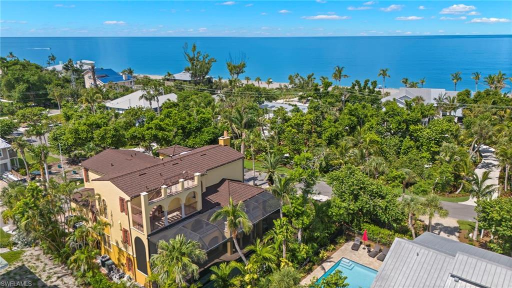 Where timeless island architecture meets modern luxury, this exceptional Captiva retreat offers the rare combination of privacy, craftsmanship, and outstanding income-producing potential. Designed by acclaimed architect Bud Lawrence and situated on a premier corner lot just steps from both the Gulf beach and bay, this 5-bedroom, 5.5-bath residence was built for both relaxed island living and unforgettable entertaining. Surrounded by lush tropical landscaping, the home centers around an impressive two-story screened lanai featuring a PebbleTec heated pool and spa, waterfall, waterslide, expansive covered living areas, and a fully equipped outdoor kitchen with a built-in Thermador grilling station. Whether hosting family gatherings or accommodating large groups, the floor plan is designed to comfortably sleep multiple generations and guests with two private primary suites, three additional guest suites, and elevator access to all levels. Inside, custom craftsmanship is showcased throughout with Brazilian cherry wood flooring, marble finishes, handcrafted Sinker Cypress doors, custom cabinetry, imported roof tiles, decorative precast architectural details, and copper gutters and downspouts. The gourmet kitchen is complemented by dual wine coolers and generous entertaining space, while extensive technology upgrades include a Control4 smart home system, a 140-inch projection screen, surround sound, and integrated outdoor audio. Perfectly positioned in the heart of Captiva Island, owners and guests can easily walk to the beach, bay, restaurants, shops, marinas, and island attractions. With its desirable location, spacious layout, resort-style amenities, and ability to accommodate larger groups, the property also offers exceptional vacation rental potential in one of Southwest Florida's most sought-after island destinations. A rare opportunity to own a distinctive Captiva residence where luxury, location, and lifestyle come together.