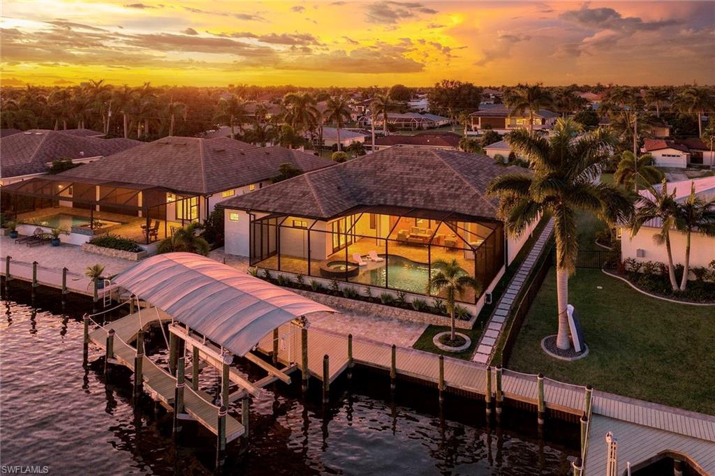 Welcome to your direct Gulf-access paradise, where expansive intersecting canal views and exceptional custom craftsmanship create the ultimate waterfront lifestyle. Built in 2024, this stunning custom residence is positioned along one of Cape Coral’s largest canals, offering a short boat ride to the Gulf of Mexico, waterfront restaurants and area beaches. The thoughtfully designed floor plan features four bedrooms, a private office and five baths. At the heart of the home is a chef’s kitchen with two oversized islands measuring approximately 9 and 10 feet, quartz countertops and high-end stainless steel appliances. Exceptional entertaining amenities include two ice makers, two full-size refrigerators and a 6-foot wine refrigerator. The spectacular indoor-outdoor living space features a linear electric fireplace and dramatic 90-degree sliding glass doors that open seamlessly to the covered lanai and pool area. Outside, enjoy a private resort-style oasis with southeastern exposure, all-day sunshine, a saltwater pool and spa and a fully equipped outdoor kitchen. Designed for luxury and peace of mind, the home features impact-resistant windows and doors throughout, along with electric shutters protecting the lanai. A spacious three-car garage provides ample room for vehicles, toys and storage, while the expansive waterfront dock includes a 24,000-pound boat lift. From its exceptional waterfront setting to its extensive luxury features and thoughtful design, no expense has been spared in creating this extraordinary Cape Coral waterfront retreat.