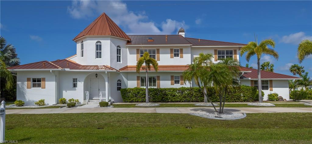 This stunning Mediterranean-style executive estate sits on two premium waterfront lots with 160 feet of sailboat canal frontage. Located in the sought-after Punta Gorda Isles community, this one-of-a-kind home delivers the perfect blend of Old World elegance and modern Florida waterfront living. Enter through an impressive tower entrance where a beautifully crafted solid oak staircase greets you upon arrival. The heart of the home is a soaring great room with its dramatic ceiling height, walls of windows flooding the space with natural light, and rich oak paneling adding warmth and sophistication. The main sitting area anchors around a classic fireplace — while the open layout accommodates multiple conversation areas perfect for entertaining on any scale. Updated 24-inch tile flows throughout the living areas on the main floor, and a wraparound second-floor balcony overlooks the entire space from above. The well-appointed kitchen features 42-inch wood cabinetry, Corian countertops, stainless steel double refrigerator/freezer, a center island with cook top, built-in desk, and casual dining area. The adjacent formal dining room is full of natural light and framed by handsome wood beam ceilings. Built-in corner cabinetry provides generous storage without sacrificing style. The expansive master suite is a private sanctuary. A newly installed private elevator connects the master level directly to the upstairs den, a convenience rarely found in residential properties. The recently updated master bath showcases white wood cabinetry, dual sinks, a deep soaking tub, and a generous walk-in shower. A large walk-in closet and a separate walk-in linen closet ensure that storage is never a concern. An adjoining air-conditioned flex room, ideal as a home gym, workshop, or creative studio includes a half bath. Both water heaters replaced 2026. A second bedroom on the main floor near the entry features a custom built-in bed and walk-in closet, served by a beautifully updated bath with wood cabinetry, marble countertops, and a walk-in shower. Upstairs, a third bedroom offers access to a large cedar-lined closet as well as a full bath featuring a tub, tile floors, and quartz countertops. At the end of the upper hallway, a handsome oak-paneled den with fireplace provides a quiet retreat. Rounding out the upper level is a delightful English-style pub complete with built-in bar seating and custom woodwork — great for entertaining and a truly unique feature that sets this property apart from anything else in the area. The screened lanai features a sparkling pool and spa alongside a gallery-style covered passage along the exterior of the great room — an elegant transition between indoors and the waterfront. The double-lot configuration and generous seawall provide ample space to dock the boat of your choice with direct sailboat access to Charlotte Harbor and the Gulf of Mexico beyond.  See this property today! You won't be disappointed!