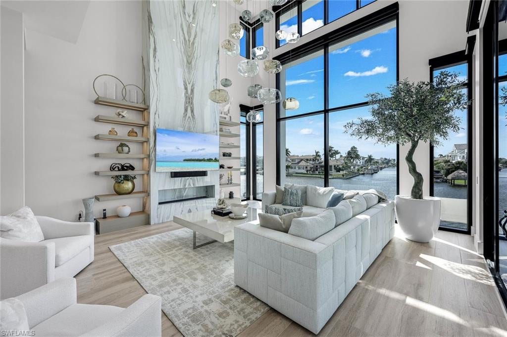From the moment you turn onto Seagull Ave, the promise of waterfront living comes into view-leading you to your own private fortress nestled at the end of the quiet, picturesque cul-de-sac! A remarkable combination of architectural presence & piece of mind, plus refined coastal luxury, this extraordinary residence offers an elevated living area situated an impressive 18.5 FEET above sea level, complimented by a Kohler whole-home generator! Built in 2025, this astonishing tri-level waterfront estate showcases cutting-edge architecture, remarkable craftmanship, and thoughtfully selected natural materials, all set on a distinctive pie-shaped homesite w/wide, exceptionally long unobstructive water views & coveted western exposure for Naples' legendary sizzling sunsets! Inside, dramatic floor to ceiling glass walls fill interiors with natural light while framing sweeping water vistas evolving beautifully throughout the day. Beyond its striking aesthetics and dynamic water views, this residence offers exceptional structural integrity, featuring solid precast concrete floor slabs reinforced with steel for added strength & stability! An exceptional blend of luxury, design and the ultimate SW Florida boating lifestyle! Featuring direct Gulf access & a covered boatslip accommodating a present 33 ft Boston Whaler Outrage plus a large deck which continues to 2 jet-ski slips, this home is designed for those who appreciate the freedom of life on the water! Inside, dual primary suites with balconies, breakfast bars, a private elevator, premium finishes, and a rare 5 car garage plus ample flex spaces provide an exceptional level of convenience & functionality. An expansive floorplan offers multiple en-suite bedrooms...designer bathrooms impress with textured shower walls, decorative glass cabinet panels plus view oriented soaking tubs! Outdoors, discover a resort inspired retreat with a sparkling pool & spa, boasting mood-relaxing fire features, a fully equipped outdoor kitchen w/ a Wolf grill & bar, & captivating Western facing water views which provide a beautiful Naples sunset backdrop! The chef inspired kitchen is a showpiece in its own right featuring custom Chicago-crafted cabinetry, exquisite/abundant Cristallo quartzite countertops AND backsplash, Wolf appliances, Sub Zero beverage drawers, an icemaker, dual dishwashers, an eye-opening spacious pantry, and an expansive island w/breakfast bar. Italian luxury porcelain wood flooring and several thoughtfully placed private seating areas throughout along with a dramatic living area fireplace which flickers beneath a modern, sculptural chandelier further enhance this home's sophisticated aesthetic! A temperature-controlled wine showcase provides the finishing touch to this extraordinary waterfront residence! Enjoy a nearby private beach club membership @ Paraiso! Elevated living, architectural substance, boating convenience & extraordinary waterfront entertaining all create an irresistible place to call home!