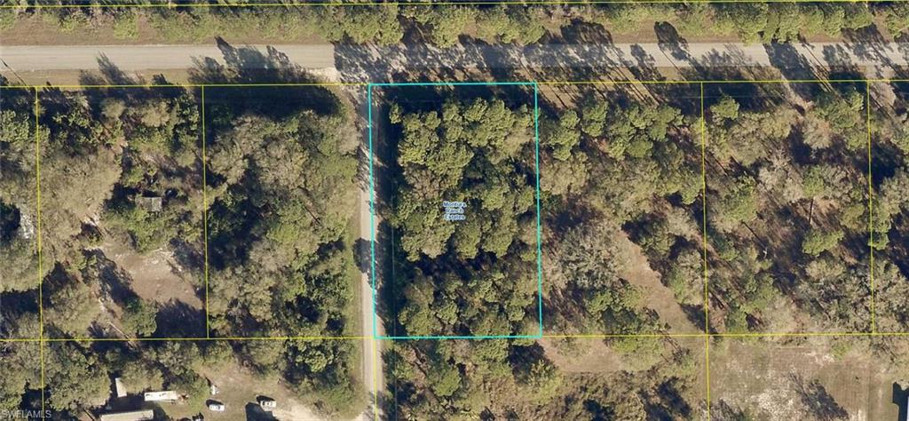 Paved road corner lot ready for clearing and new construction.