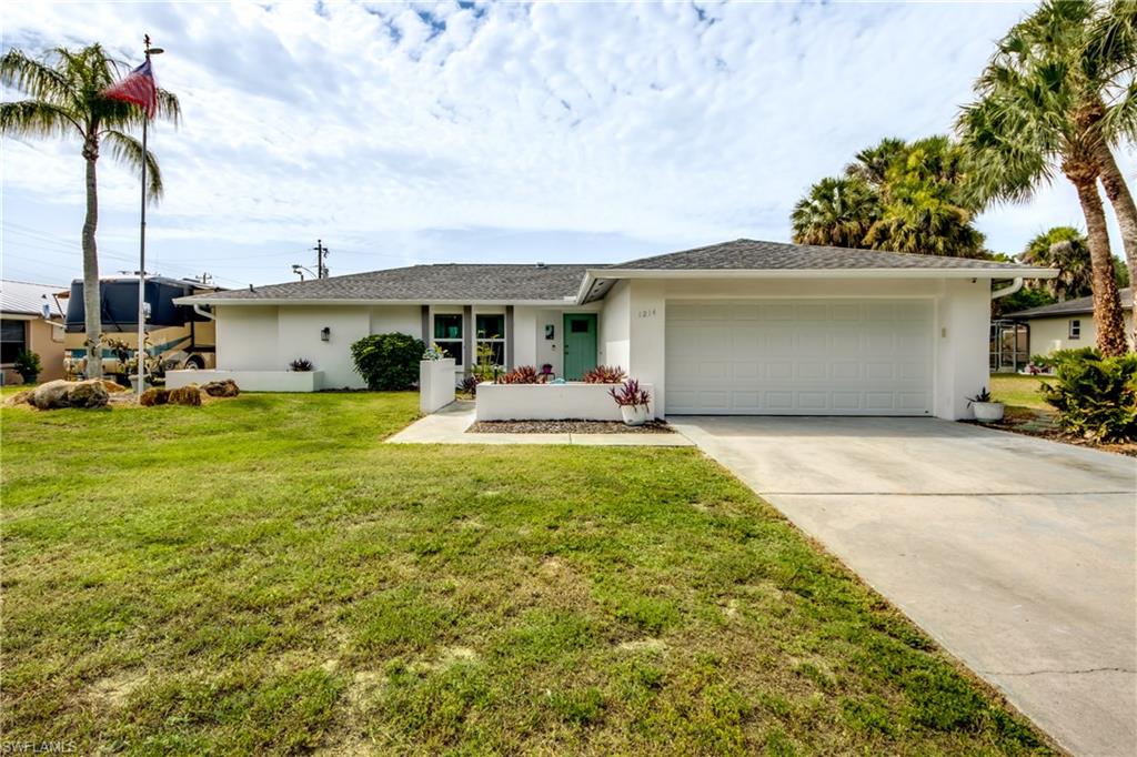 Set in an established East Lehigh Acres neighborhood, 1214 Baldwin Pl is a move-in-ready pool home that offers comfort, function, and great curb appeal in one single-story package. Inside, an open-concept layout with coastal-colored plank tile flooring throughout connects the living, dining, and kitchen areas, where an updated kitchen features white shaker cabinetry, stainless steel appliances, marble-look quartz countertops, and a breakfast bar with pull-up seating alongside the eating nook. Both bedrooms are generously sized with ceiling fans, and the primary bedroom, guest bedroom, and dining area all offer direct access to the pool, while the two refreshed bathrooms showcase modern vanities and elegant vanities with anti fog light up mirror in the primary and framed mirror above the vanity in the guest suite.  Outside, a private screened-in pool with a spacious covered lanai sets the stage for year-round entertaining, complemented by a large backyard framed by mature trees. Additional highlights include a wide driveway, an attached two-car garage, and a 50-amp RV hookup, along with a major peace-of-mind upgrade: impact-rated windows, front door, and garage door for added storm protection and energy efficiency. Newer roof ( w/ 3rd nail added insurance discount ) all the while being Ideally located just minutes from shopping, dining, and groceries along the Lee Boulevard corridor, the home also offers quick access to SR-82, SR-80 and I-75 for an easy commute to Fort Myers, with RSW International Airport, area golf courses.