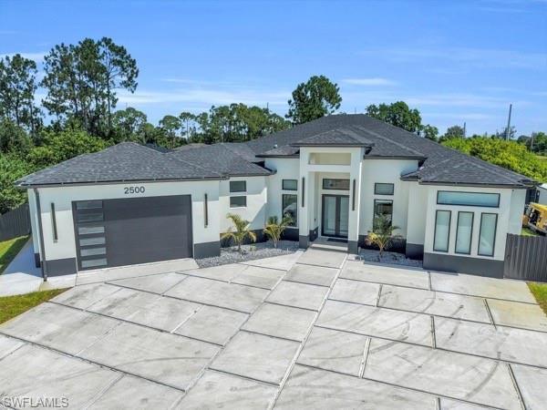 Welcome to a one-of-a-kind modern luxury residence where exceptional design meets everyday comfort. Situated on an oversized 0.38 -acre lot, this stunning home was thoughtfully designed with high-end finishes and impressive architectural details throughout. From the moment you step inside, you’ll be captivated by the 12-foot ceilings, expansive open-concept layout, and abundant natural light. The gourmet kitchen is a true showpiece, featuring a massive quartz waterfall island, sleek European-style cabinetry, premium built-in appliances, and generous space for entertaining. The owner’s suite offers a true retreat with a spa-inspired bathroom, an oversized custom walk-in closet, and elegant finishes that create a relaxing atmosphere. Luxury continues throughout the home with motorized floor-to-ceiling window shades, two high-efficiency air conditioning systems for maximum comfort, a whole-home security alarm system, impact-resistant windows and doors, designer lighting, porcelain tile flooring, and a premium whole-house water treatment system. Step outside to an expansive covered lanai overlooking the fully fenced backyard, offering plenty of room to relax, entertain, or even add your dream pool. Every detail of this home has been carefully selected to deliver elegance, functionality, and peace of mind. This isn’t just a house—it’s a lifestyle. Schedule your private showing today and experience everything this extraordinary home has to offer.
