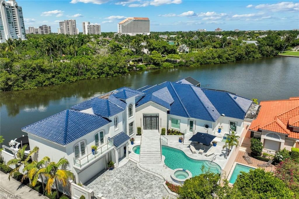 One or more photo(s) has been virtually staged, AI generated or rendered.  
Discover an extraordinary Naples, Florida waterfront lifestyle at 4900 Gulf Shore Blvd N, a modern luxury estate hidden behind a private wall in an enclave of just six single-family homes, this rare property offers 295 feet of waterfront, exceptional privacy with no neighboring residence at one end, multiple boat lifts and private beach access shared with only five neighboring homes. Few Naples luxury waterfront properties combine this level of boating, beach access and seclusion.
Designed and completely renovated for effortless indoor-outdoor Florida living, the four-bedroom, six-bath smart home features refined neutral finishes with abundant natural light and water views from every bedroom. A dramatic entry foyer opens to an expansive living room with vaulted ceilings, a fireplace and sliding glass doors connecting to the outdoors. Designer chandeliers throughout, a striking chrome-and-glass staircase, marble floors and new sculpted carpeting elevate the contemporary design.

The chef's kitchen features premium Gaggenau appliances, double sinks, a generous island with seating and storage, and custom panel appliances. The home offers dedicated coffee, wine and service bars for exceptional entertaining. Four fireplaces—in the living room, den, primary bedroom and primary bathroom—bring warmth to the home's sleek architecture. Thoughtful built-in storage throughout adds everyday ease.
The waterfront primary suite is a private retreat with its own balcony, picture window, fireplace and custom luxury closet. Its spa-inspired bath includes a walk in shower with two shower heads, two water closets and a freestanding jetted, self-drying tub positioned to enjoy stunning water views. A flexible multigenerational or in-law suite offers a kitchenette and double French doors to a private balcony. The first floor bedroom offers another balcony and built in Murphy bed.
Embrace the ultimate resort lifestyle with a private pool offering full sun exposure, spa, cold plunge and cryotherapy sauna. An expansive caged lanai features comfortable seating, outdoor dining and an outdoor kitchen, while additional seating areas on the open decks invite relaxation and waterfront entertaining.Enjoy boating from multiple lifts, beach days through the enclave's shared private access and the coastal lifestyle that defines Naples. Flood panels at every lower level entry point give peace of mind. With remarkable waterfront frontage and an exceptionally secluded setting on Gulf Shore Boulevard North, this modern estate is a legacy opportunity.