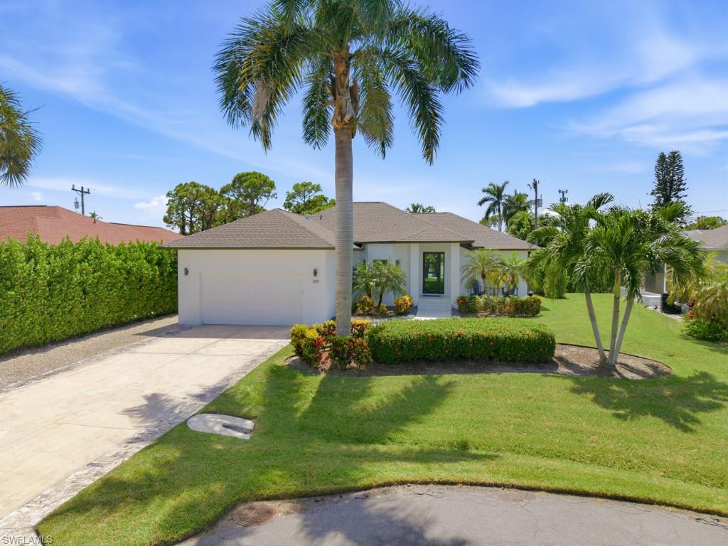 This gorgeous 3 bedroom home has been completely renovated into a contemporary coastal designed masterpiece.  Enjoy modern Florida living at its best with a huge lanai, great for entertaining.  The private backyard pool enclosure offers comfortable everyday living with plenty of space for relaxing and recreation.  The elegant interior has beautiful white porcelain flooring, tray ceilings, impressive backsplash in kitchen and baths, lots of natural light and luxurious appointments throughout.  The master bedroom suite is its own retreat-right off the pool area with double vanity sink, enclosed shower, and walk-in closet.  The charming front porch is elevated and surrounded by beautiful landscaping. Enjoy the Island lifestyle with convenient access to shopping, dining, and nearby beaches.