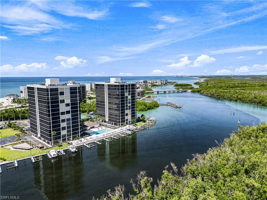 Beautiful 4th-floor corner residence at the coveted Bay Harbor Club on Bonita Beach, offering breathtaking Gulf and Bay views, deeded beach access, and BOAT DOCK #1 INCLUDED! This coastal retreat features an expansive wraparound lanai with panoramic water views, creating the perfect setting to enjoy both sunrises over the Bay and spectacular Gulf sunsets. A true beach and boater’s paradise, the residence offers deeded beach access just steps away along with convenient Gulf access by boat. The spacious, open floor plan offers 1,345 sq. ft. under air with 2 bedrooms, 2 bathrooms, floor-to-ceiling sliders, and electric hurricane shutters. The kitchen features white cabinetry, granite countertops, stainless steel appliances, a breakfast bar, and an adjacent dining area. The primary suite showcases beautiful Gulf views, private lanai access, and an ensuite bath with dual vanities, a makeup vanity, and a spacious shower. This residence offers excellent rental potential or the perfect opportunity for a relaxing beach retreat. Bay Harbor Club features deeded beach access directly across the street, a bayside pool, tennis and pickleball courts, shuffleboard, kayak launch, grilling areas, and beautifully maintained grounds. Ideally located just steps from waterfront dining and minutes from Mercato, Promenade at Bonita Bay, Coconut Point, and all that Naples and Bonita Springs have to offer.