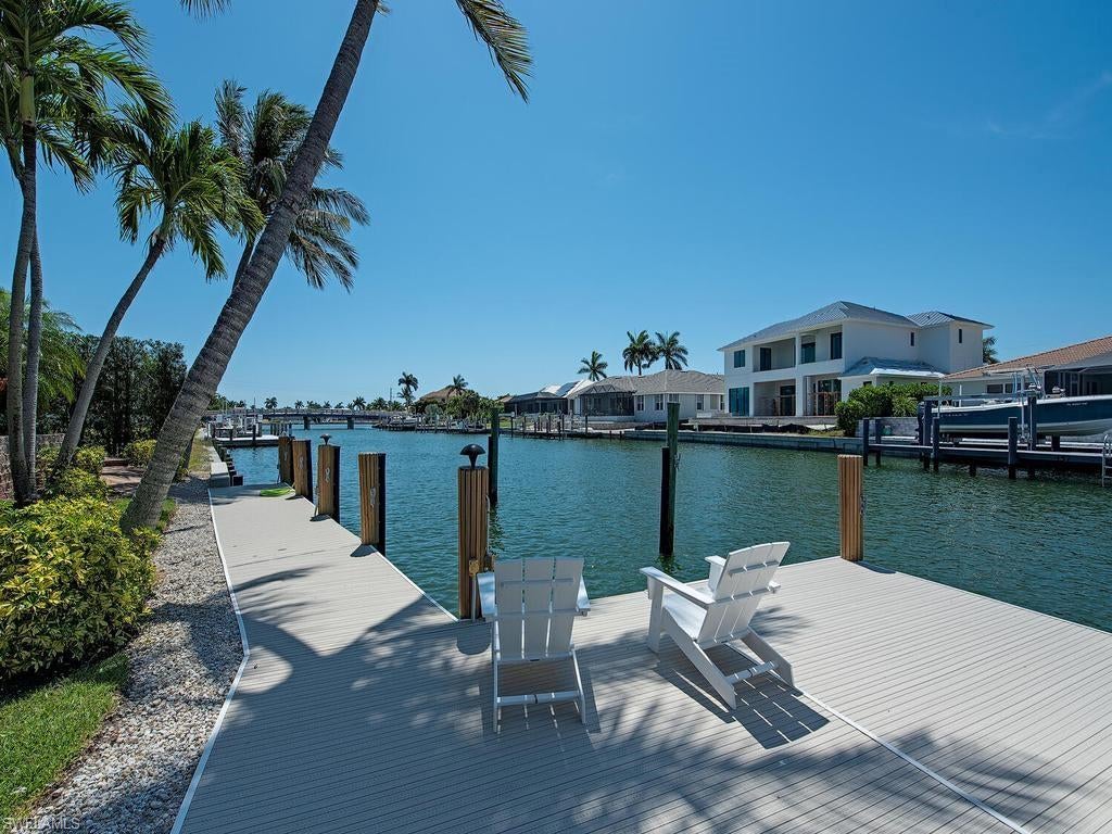 Experience the ultimate Marco Island lifestyle in this magnificently remodeled waterfront residence, ideally positioned with quick, direct (no bridge) access to Collier Bay and the Marco River and within easy walking distance of highly desirable Tigertail Beach. This exceptional three-bedroom plus den, two-and-a-half-bath home seamlessly blends sophisticated coastal interiors, expansive outdoor living and tranquil water views in one extraordinary island setting.

From the moment you enter, refined details set the tone. Patterned travertine marble flooring flows through the spacious living areas, complemented by recessed ceilings, elegant crown molding, custom built-ins and a sophisticated coastal-inspired palette. Floor-to-ceiling recessed sliding glass doors throughout the home fill the interiors with natural light and open completely to unite the indoor and outdoor living spaces.

The expansive screened lanai is designed for the quintessential Florida lifestyle, overlooking the waterfront pool, heated spa and sparkling water feature. A covered dining area, outdoor kitchen and bar, stainless steel grill and multiple lounging and conversation areas create an exceptional setting for entertaining or simply relaxing while enjoying the home’s western exposure and spectacular sunsets.

Inside, the spacious living room showcases beautiful water views and flows effortlessly into the dining area and gourmet kitchen. Custom cabinetry, granite countertops, high-end stainless steel appliances and an expansive bar counter combine style and functionality while creating a natural gathering place for family and friends. A dedicated home-office area provides additional versatility.

The luxurious primary suite is a private waterfront retreat with direct lanai access and serene water views. Its spa-inspired bath features a dramatic Roman soaking tub, custom walk-in shower, intricate tilework, high-end fixtures and dual vanities. Two additional bedrooms provide beautifully appointed accommodations for family and guests and share an elegant bath with black granite countertops and a tiled walk-in shower.

Outside, Marco Island’s natural beauty becomes part of everyday life, with surrounding waterways frequented by tropical birds, dolphins and manatees. The coveted location near the island’s northern end places Tigertail Beach, boating, golf, exceptional dining, shopping and recreation within easy reach.  

Beautifully remodeled and designed to embrace its waterfront surroundings, this distinctive residence offers an exceptional opportunity to enjoy sophisticated island living, unforgettable sunsets and the very best of Marco Island.