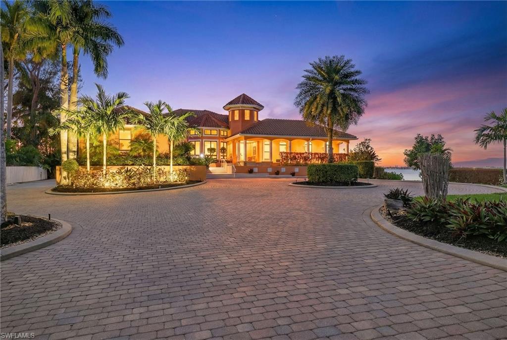 Set behind private gates on nearly two acres along the Caloosahatchee River, 2600 McGregor Blvd offers an extraordinary combination of privacy, scale, waterfront living, and direct boating access. With 163 feet of river frontage, the property captures sweeping open-water and sunset views from one of Fort Myers’ most iconic corridors.     Designed for refined single-story living, this custom residence features four bedrooms, four-and-a-half baths, a private den, and expansive spaces for everyday living and entertaining. Soaring ceilings, impact-rated windows and doors, elegant millwork, and thoughtfully designed architectural details create a timeless sense of sophistication throughout.     At the heart of the home, the chef’s kitchen offers generous preparation space, a center island, gas cooking, and effortless connection to the family room. Zero-corner sliders open the living space to the outdoors and frame panoramic river views, while a butler’s pantry and dedicated wine storage make entertaining exceptionally easy.     The primary suite is a private waterfront retreat featuring panoramic river views, dual custom closets, a spa-inspired bath, and its own fitness area.     For the automobile enthusiast or serious collector, the property offers an exceptional feature: an oversized three-car garage complemented by an expansive garage and storage area beneath the residence with capacity for approximately nine additional vehicles. Ideal for a vintage or specialty automobile collection, recreational equipment, or extensive private storage, this remarkable space sets the property apart.     Outdoor living takes full advantage of the riverfront setting with a heated pool and spa, generous covered entertaining areas, and a private dock with two boat lifts providing direct boating access to Fort Myers Beach, Sanibel, Captiva, and the Gulf. Recently installed Garrison flood panels provide an additional layer of protection.     Located along historic McGregor Boulevard, within walking distance of the Edison & Ford Winter Estates and just minutes from downtown Fort Myers, 2600 McGregor Blvd brings together exceptional waterfront, boating, privacy, and space in a distinctive Fort Myers riverfront estate.