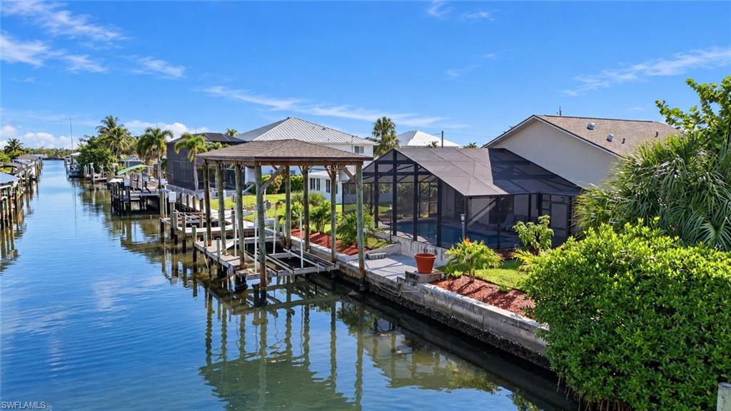 One or more photo(s) has been virtually staged, AI generated or rendered.  Your Pool. Your Boat. Your Waterfront Escape. Beautifully renovated and move-in ready, this canal front home brings the dream together with a private pool, covered boathouse, extensive updates inside and out and beach access is just a short walk away. Featuring 1,520 square feet of interior living space, the home showcases new tile flooring, new interior doors, beautifully redesigned bathrooms and an updated kitchen with new cabinetry, brand new appliances and granite countertops. A versatile bonus room offers space for a den, formal dining room or a comfortable retreat of your own. Outside, enjoy poolside afternoons and evenings overlooking the canal. New pool equipment, a new pool cage and screens, fresh landscaping and a newly refreshed yard compliment the waterfront setting. The covered boathouse adds an inviting home for your boat, while the oversized two-plus-car garage provides generous room for vehicles and storage. Additional improvements include a new roof, new paver driveway, new garage door and new garage door openers. The home has been professionally remediated and cleaned following completion of construction. From the updated interiors to the inviting outdoor spaces, this is your opportunity to settle into the waterfront lifestyle you've been dreaming about. Come experience it for yourself!