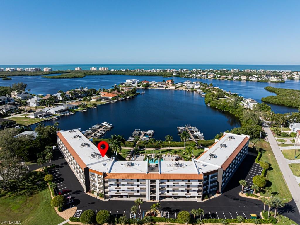 BOATER'S PARADISE! TURNKEY CONDO WITH DEEDED DOCK & 10K LIFT WITH DIRECT, EASY ACCESS TO THE GULF OF AMERICA: Experience ultimate coastal living in this stunning 3rd-floor, two-bedroom, two-bathroom waterfront residence. Unit offers picturesque northwestern views of Little Hickory Bay and the Gulf ofAmerica. Perfectly positioned, the building's unique architectural angling shields your private lanai from the intense afternoon sun, allowing you to comfortably enjoy gentle breezes and spectacular waterfront vistas throughout the day.  Tastefully furnished to create a warm and inviting atmosphere, this home has been meticulously maintained and features a newer HVAC system (installed May 2023) and a large hot water heater (installed February 2026). Enjoy complete peace of mind with full storm protection, including hurricane-impact windows, doors, and an electric lanai screen. Additional features include an assigned covered parking space, ample guest parking, and a large private storage unit with generous space for beach and boating gear. Situated within walking distance of Bonita Beach, local dining, and shopping, this exceptional property demands your attention and warrants a personal tour to fully appreciate its magnificence.