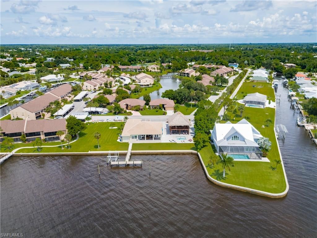 A Once-in-a-Lifetime Riverfront Estate. Set on an extraordinary three-lot homesite with 141 feet of deep-water frontage along the Caloosahatchee River, this remarkable waterfront estate captures breathtaking panoramic views from one of the river's widest stretches. Offering exceptional privacy, an expansive footprint, and endless possibilities, this rare property allows you to create your own private waterfront resort. The additional lot provides the opportunity for a private estate expansion, a recreational tennis/pickleball court combination, a custom boathouse, or another luxury enhancement tailored to your lifestyle. Few properties in SWFL offer this level of versatility and opportunity. Crafted by renowned Rutenberg Homes, this well maintained residence offers 2,663 sf under air. Designed for the boating enthusiast, the property features a new composite dock with room to accommodate a 55-foot-plus yacht, a 15,000-pound boat lift, and direct deep-water Gulf access, making it the perfect home base for yachting, cruising, or world-class fishing adventures. Updated with recent improvements,with a new roof (2025), new kitchen appliances (2024), an impact-rated hurricane garage door, and a reconstructed seawall (2025). The seawall was raised approximately two feet, backfilled, and reinforced with new seawall panels and anchors, providing enhanced protection, durability, and long-term value for this premier riverfront property. Elegant glass double entry doors welcome you into a light-filled, open-concept floor plan where expansive impact-resistant windows frame breathtaking river views from nearly every room. A  spacious kitchen with a casual dining area along with a formal dining room that offers a setting for entertaining. The luxurious owner's suite is a peaceful waterfront retreat featuring 8-foot French doors that open to the beauty of the outdoors. A sparkling heated pool, complemented by a full pool bath with a steam room creating the perfect place to relax after a day on the water. The crown jewel of this extraordinary property is the spectacular two-story tiki pavilion-an entertainer's dream unlike anything else on the market. The upper level features a fully equipped summer kitchen, bar, dumbwaiter, and elevated gathering area with sweeping river views, creating the ultimate setting for sunset cocktails, celebrations, and unforgettable evenings. The expansive lower level provides abundant covered entertaining space, additional covered parking, and room for all your recreational toys. Located within the prestigious Admiralty Yacht & Racquet Club, this homeowner has the option—but isn't required—to join the private club and enjoy boating, tennis, pickleball, dining, and a vibrant social calendar. This is far more than a luxury home—it is a private waterfront resort offering unmatched views, exceptional boating access, and the opportunity to create a truly one-of-a-kind riverfront estate.