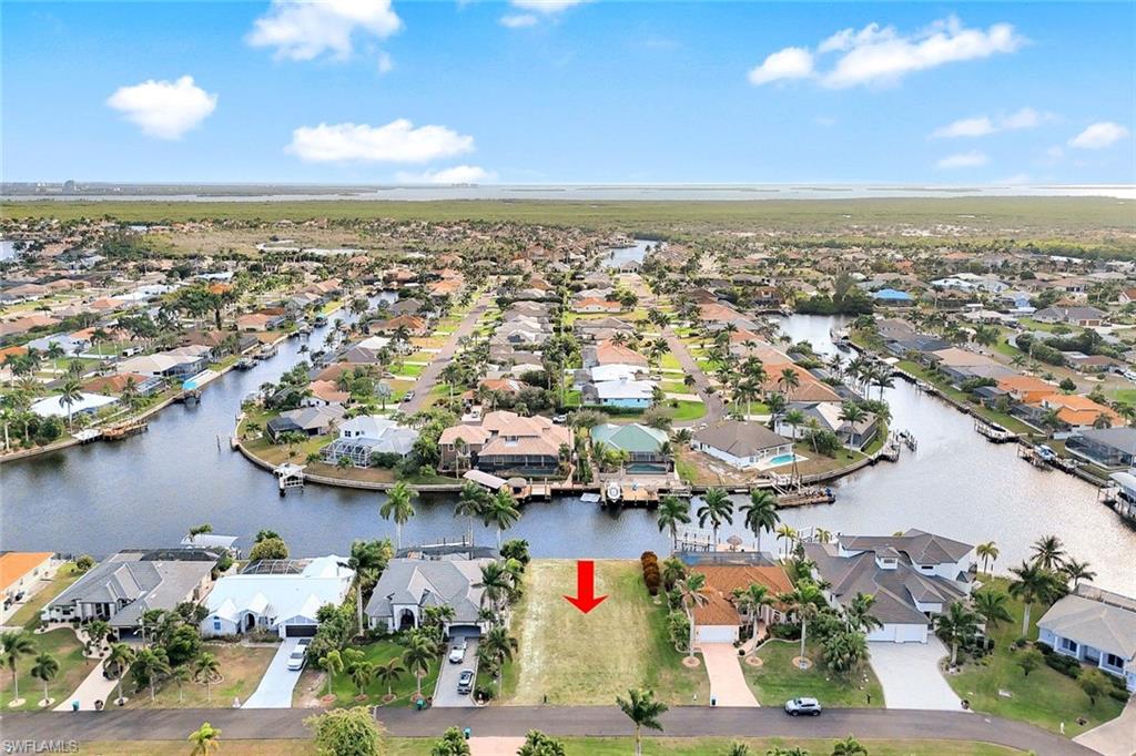 Build Your Paradise!!  *SOUTHERN REAR EXPOSURE GULF ACCESS LOT IN SW CAPE CORAL!!*  *DUAL INTERSECTING CANAL VIEWS TO THE EAST & WEST!!*  This is an exceptional opportunity to secure a *PRIME PIECE OF WATERFRONT REAL ESTATE* with *ASSESSMENTS PAID* in the highly desirable Southwest Cape Coral area.   Imagine designing your dream Florida home to maximize the coveted southern rear exposure, which bathes your future lanai, pool, and dock in glorious sunshine all day, year-round—perfect for the *ULTIMATE OUTDOOR LIFESTYLE*. This is a *BOATER'S DREAM*, offering prized gulf access to the Caloosahatchee River and the Gulf of Mexico. Save significant time and expense as a *SEAWALL IS ALREADY IN PLACE*, providing a secure and valuable foundation for your waterfront construction plans and future boat dock. Nestled in the sought-after SW Cape, you'll be *CLOSE TO THE AREA'S BEST AMENITIES*, including the marinas at Tarpon Point and Cape Harbour, fine dining, and shopping. Southern rear exposure Gulf Access lots are consistently the most sought-after properties in Southwest Florida!