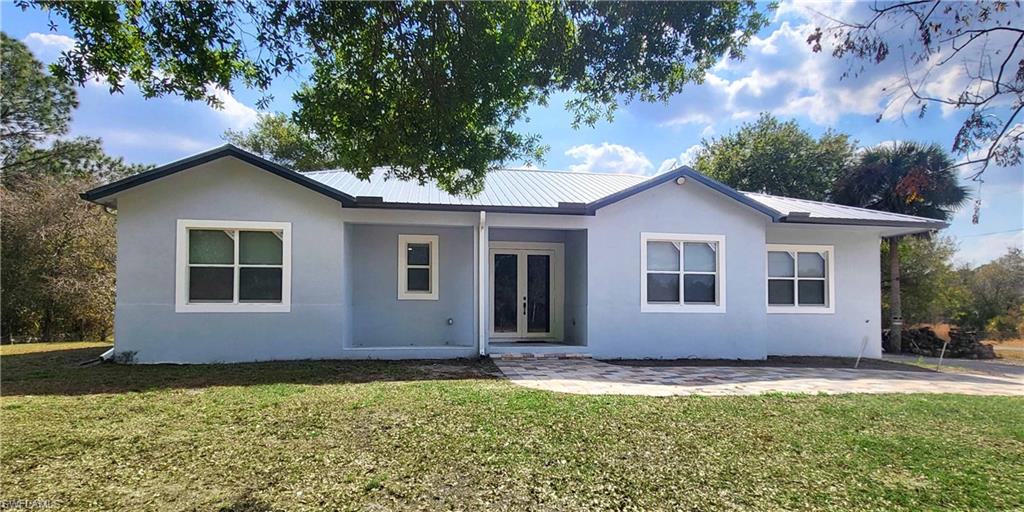 PRICE ADJUSTMENT! Motivated Seller. Discover this STUNNING 2024-built home in Montura Ranch Estate, Florida, featuring 2,142 sqft. OF LIVING SPACE. This concrete home blends modern design with luxurious finishes and a functional layout. The living area is EXCEPTIONAL SPACIOUS. Complemented by HIGH CELINGS that create an open, bright atmosphere. The home offers 3 BEDROOMS, 2 FULL BATHROOMS, and a FLORIDA ROOM that can also serve as a den or additional workspace. The MASTER BEDROOMS measures 13x25 ft, with a spacious ensuite including a shower, soaking tub, and double vanity. The kitchen boasts wood cabinets and QUATZ COUNTERTOPS, A BIG ISLAND along with high-end stainless steel appliances. Other highlights include a front porch, smoke detectors, a five-ton AC system, tile flooring, paved driveway, and an elegant gated entrance. All this sits on a private 1.25-acre lot, fully fenced and featuring FRUITS TREES as COCONUTS, PAPAYA, GUAVA, and PASSION FRUITS, creating your own tropical oasis. The property also features a spacious BACKYARD SHED that can be used for tool storage, a workshop, or additional workspace.With no HOA fees, this home offers comfort, privacy, and style in every corner.