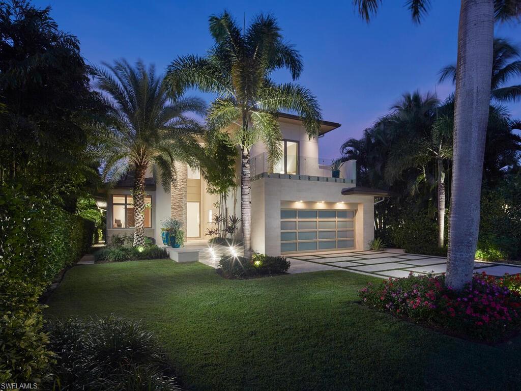 One or more photo(s) has been virtually staged, AI generated or rendered.  Ideally situated on a peaceful street in the heart of Old Naples, this newly built custom home by London Bay is just three blocks from the beach and steps from the exceptional shopping and dining of 5th Avenue South and 3rd Street South. An open floor plan highlights luxurious finishes, thoughtful design, and meticulous attention to detail throughout. The spacious kitchen features a 13-foot island, an expansive walk-through pantry, and a striking combination of rift oak and high-gloss white cabinetry, complemented by wide-plank oak floors. An open formal dining room and generous great room with a bar flow seamlessly through pocketing sliding glass doors to the covered outdoor living area. Designed for entertaining and relaxation, the private outdoor retreat offers a fireplace, outdoor kitchen, automated screens, pool, tranquil pond and water feature, and a beautifully appointed garden shower, all surrounded by tropical landscaping. Upstairs, two guest suites and a comfortable bonus room accompany the primary suite, which features two walk-in closets and a private balcony overlooking the lush rear yard. Additional amenities include a two-and-a-half-car garage, elevated generator and air-conditioning units, tankless water heaters, and natural gas service.