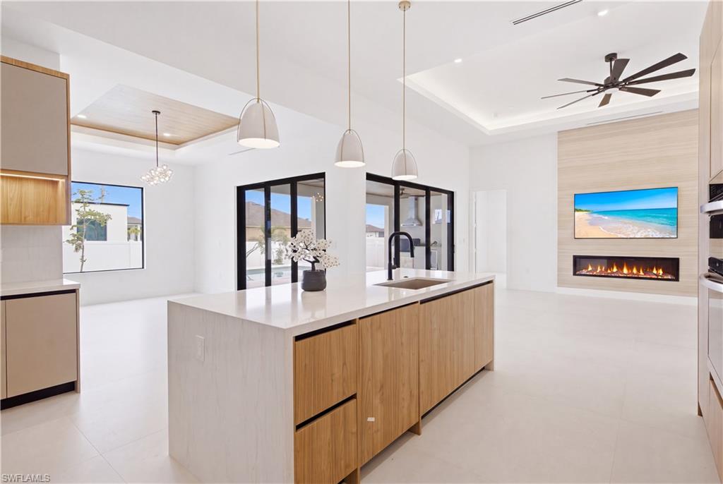 STUNNING NEW CONSTRUCTION | MODERN LUXURY | POOL HOME | MOVE-IN READY! Exceptional 2,420 sq ft contemporary home w/ sophisticated architecture, premium craftsmanship & luxurious finishes create the perfect SWFL retreat! This 3 bed + flex den, 3.5 bath home offers impressive open-concept floor plan designed for effortless entertaining & everyday living! Elegant front elevation, designer landscaping, paver driveway, 3-car garage & striking covered entry w/ soaring columns, modern lighting & frosted double glass doors. Discover inside w/ 48x48 designer porcelain tile throughout, soaring ceilings w/ tray & wood accents, abundant natural light, impact windows & doors & clean contemporary lines that define every space! Spectacular great room features linear electric fireplace w/ floor-to-ceiling feature wall, creating the perfect gathering space while oversized sliding doors seamlessly blend indoor & outdoor living. Chef-inspired gourmet kitchen showcasing sleek European-style custom cabinetry, Taj-Mahal inspired quartz countertops w/ waterfall island, under-cabinet LED lighting, pot filler, built-in wall oven & microwave, induction cooktop, hidden range hood, integrated cabinetry, designer pendant lighting, spacious pantry & premium stainless appliances. Formal dining area is highlighted by an impressive glass-enclosed wine display, adding a sophisticated focal point for entertaining! Luxurious owner's suite is a true private retreat featuring lanai access, custom illuminated walk-in closets & spa-inspired ensuite w/ freestanding soaking tub, dual floating vanities, LED mirrors, oversized dual walk-in showers w/ rainfall fixtures, handheld sprayers, body sprays & designer finishes throughout. Split-bedroom layout provides outstanding privacy w/ spacious guest suite featuring its own ensuite bath, plus additional guest bedroom, full bath & versatile flex den ideal for home office, media room, or fitness space. Outside oasis w/ expansive covered lanai showcasing a beautiful flat wood ceiling, built-in outdoor kitchen complete w/ grill, hood, sink, beverage refrigerator & storage, all overlooking sparkling custom pool surrounded by elegant marble decking & fully fenced backyard offering privacy & plenty of room to relax or entertain. Outdoor shower and cabana pool bathroom adds convenience after enjoying the Florida sunshine! Additional features include stylish laundry room w/ custom cabinetry, utility sink, washer & dryer, designer lighting throughout, modern interior doors, floating vanities, upscale plumbing fixtures, custom built-in closet systems, extensive storage & meticulous attention to detail in every room. Conveniently located near shopping, restaurants, parks, schools, golf, boating, healthcare, and all the best amenities Cape Coral has to offer, this remarkable home combines luxury, comfort & modern design in one unforgettable package!