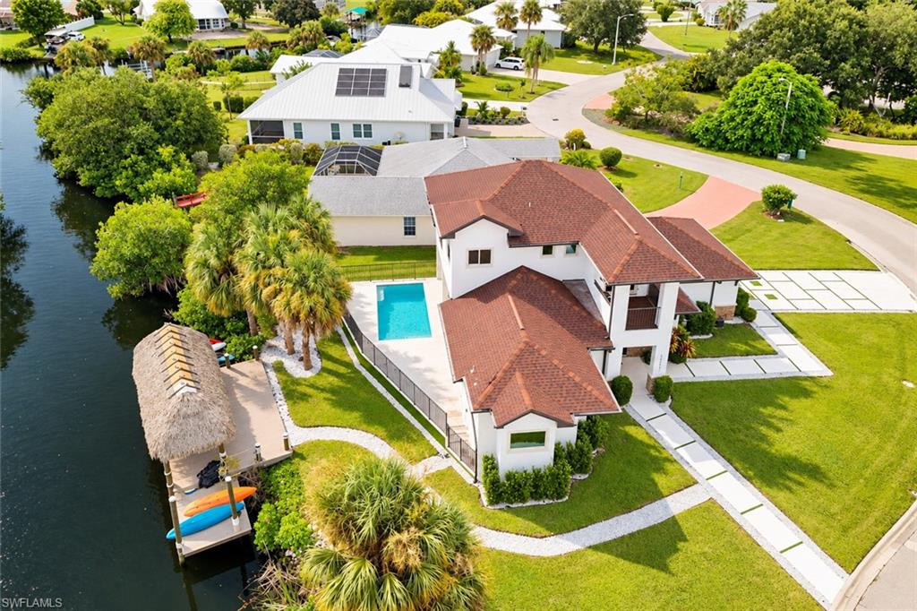 CUSTOM-BUILT WATERFRONT RETREAT — PRIVATE POOL — MARBLE WATERFALL ISLAND — FIRST-FLOOR PRIMARY SUITE — PRIVATE DOCK & TIKI HUT! Experience an inviting blend of elegance and waterfront living at 15361 River Cove Ct. Built in 2022, this 3-bedroom, 2.5-bath residence in Waterway Cove occupies a corner lot with no neighboring home on one side, pairing distinctive interiors with exceptional spaces for relaxing and entertaining. HIGH CEILINGS, abundant natural light, and ITALIAN MARBLE FLOORING in the main living area create a stunning first impression. The beautifully appointed kitchen features SOFT-CLOSE WHITE CABINETRY, stainless steel appliances, and a statement MARBLE WATERFALL ISLAND with counter seating. The open layout connects the kitchen, dining, and living spaces, while sliding glass doors lead to the COVERED POOLSIDE PATIO for effortless indoor-outdoor living. The FIRST-FLOOR PRIMARY SUITE offers direct poolside access and a spa-inspired ensuite featuring a FREESTANDING SOAKING TUB, FRAMELESS GLASS SHOWER with pebble-tile flooring, DUAL-SINK VANITY WITH A QUARTZ COUNTERTOP, and a spacious WALK-IN CLOSET WITH CUSTOM SHELVING. Upstairs, a versatile LOFT/STUDY with built-in cabinetry and a beverage refrigerator opens to a PRIVATE CANAL-VIEW BALCONY an inviting setting for morning coffee or unwinding at the end of the day. Two additional bedrooms and a full bathroom provide comfortable accommodations for family and guests. Outside, a PRIVATE POOL, TRAVERTINE DECK, and covered lounge area create your own Florida escape. At the water’s edge, a PRIVATE WOODEN DOCK WITH A TIKI HUT offers a memorable setting for shaded waterfront dining and peaceful afternoons beside the canal. Currently used as a vacation rental, this residence has NO RENTAL RESTRICTIONS and allows Airbnb rentals, offering an excellent opportunity for buyers seeking an income-generating investment. With its statement finishes, inviting outdoor spaces, and canal-front setting, this distinctive home brings luxury and relaxed waterfront living together in North Fort Myers.