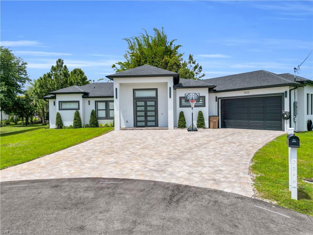 Welcome to 3510 9th Ct W, where modern design, space and functionality come together on an oversized cul-de-sac lot in Lehigh Acres. Built in 2024, this beautifully designed home offers 3 bedrooms, 3 full bathrooms, nearly 2,000 sq. ft. of living space and a 2-car garage, all with NO HOA.

From the moment you step inside, the clean contemporary design makes an impression. High ceilings, recessed lighting, large-format tile flooring and a striking black-and-white color palette flow throughout the home. The open-concept layout creates a seamless connection between the kitchen, dining and living areas, making the space ideal for both everyday living and entertaining.

The kitchen is the centerpiece of the home, featuring an oversized quartz waterfall-style island with seating for six, white shaker cabinetry, stainless steel appliances, modern black hardware, statement lighting and a dramatic black backsplash that gives the space a custom look.

Retreat to the spacious primary suite and spa-inspired bathroom featuring dual vanities with illuminated mirrors, a freestanding soaking tub, separate walk-in shower and beautiful floor-to-ceiling tile finishes. The additional bathrooms continue the home's modern aesthetic with upgraded tile showers, rainfall-style showerheads, illuminated mirrors and contemporary finishes.

Even the laundry room was designed with functionality in mind, offering extensive cabinetry, quartz countertops, utility sink and plenty of additional storage and workspace. The attached 2-car garage features a finished epoxy floor for a clean, polished look.

Step outside and enjoy one of this property's standout features — a covered lanai with a built-in outdoor kitchen complete with sink and cooktop, ready for weekend BBQs and entertaining.

The oversized approximately .37-acre cul-de-sac lot provides plenty of outdoor space with room to add your dream pool and create your own private Florida backyard oasis. Impact-resistant windows and doors add another valuable feature to this already impressive home.

Modern construction, generous lot size, upgraded finishes, outdoor entertaining space and NO HOA make this property stand apart from the typical home.