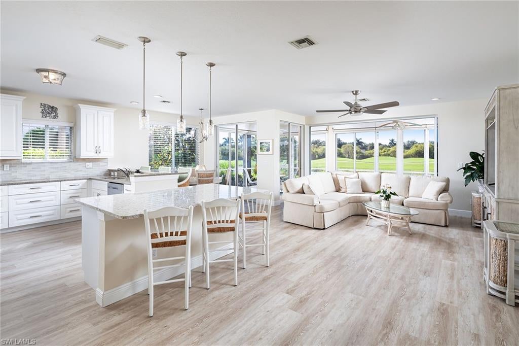 Delightfully sunny, this pristine end-unit coach home offers fabulous forever lake and golf course vistas of the picturesque seventh hole with no other buildings in sight, complete with preferred southern exposure. IMMEDIATE FULL GOLF MEMBERSHIP AVAILABLE.  The light and bright airy feel is complemented by an open great room layout, fabulous renovated white kitchen is ideal for entertaining with large counter-level quartz island, beverage refrigerator, 42-inch cabinetry, stainless steel appliance package, new wide plank white oak LVT flooring, new light fixtures, fans and LED lighting throughout. Perched on one of the best lots in the complex with across the street to the community pool, eight guest parking spots and the mailboxes, this lovely condominium comes complete with one of the quietest locations in the development. Features include a wraparound lanai with pocket sliders and hurricane shutters, additional golf cart garage, newer building roof, loads of storage, main closet custom built-ins, large walk-in closet in one guest room, built-in desk in the other guest bedroom and paver driveway completes the package. Immediate full golf membership available in this one-of-a-kind club with an active lifestyle and a variety of memberships available (minimum social membership required). Estero Country Club offers a beautiful, award-winning Gordon Lewis golf course, recently renovated clubhouse with fabulous dining options inside and out, four tennis courts, six pickleball courts, state-of-the-art fitness center, bocce and an abundance of social activities throughout the year.