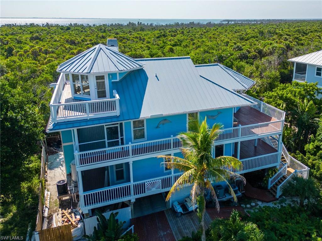 UPPER CAPTIVA CANAL HOME. Room for two boats. Might want to update the bathroom. Beautiful private views across the State Park to Pine Island from this gorgeous 3 bedroom plus a den & 3.5 bathroom home. It has everything you would want from an island home including protected docking for your boats on a navigable canal which leads out to the Gulf of Mexico and the Intracoastal Waterway, an elevator to bring groceries and supplies up to the kitchen, all windows are hurricane impact windows, cedar ship-lap exterior siding, wood burning fireplace, an upper mezzanine area above the living room which could be a studio or office, plenty of room for guests, a beautiful kitchen with big windows showing the view to the State Park, wide decks wrap around the house on both floors, a large screened-in pool with a shower and bathroom, new electric system inside and out, new roof, newly painted decks, newly painted exterior. Also, recent maintenance check on the Elevator. The beach is just down the sandy path to a parking area with access to the widest beach on the island. This island home could be an exceptional income producing property. 
Please make an appointment to see this wonderful home soon.
