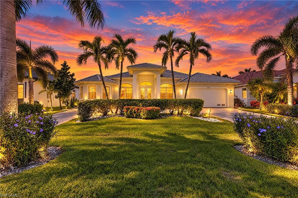 Set on an inviting, palm-lined street near Surfside Boulevard, this Southwest Cape Coral home combines Gulf access, western sunset views and spacious interiors with distinctive architectural character.

A circular paver driveway and mature tropical landscaping create a welcoming arrival. Inside, the generous great room features a decorative tray ceiling reaching 14 feet at its highest point, while 10-foot-tall sliding glass doors frame views of the pool and canal. Natural light, large windows and newly installed living-room tile enhance the open, airy feel of this 3-bedroom, 2-bath home.

The spacious kitchen brings together white cabinetry, black granite countertops and a breakfast bar, complemented by a breakfast nook and separate dining area. The split-bedroom layout places the primary suite apart from the two guest bedrooms, offering privacy for owners and visitors alike. Both the primary suite and one guest bedroom open directly to the lanai and pool deck. The primary suite also includes a walk-in closet, dual sinks, a soaking tub and a shower.

The great room opens onto a spacious covered lanai, with the adjoining pool deck and screened enclosure spanning the full width of the home. The oversized saltwater pool features solar and electric heating, alongside a spa with a spillover waterfall. Western exposure brings sunset views over the canal, and a covered outdoor shower recessed into the home features a glass enclosure.

Foxtail, pygmy date and coconut palms, flowering plants and an avocado tree give the grounds an established tropical character. Paver walkways extend along both sides of the home to the waterfront. The private dock includes a Captain’s Walk, a 10,000-pound boat lift, water and electricity; wood decking was replaced in 2022. Gulf access requires no lock passage; bridge restrictions apply.

Located near the Oasis school campus, the home is offered partially furnished and includes an attached two-car garage and Bosch washer and dryer. No HOA; all utility assessments paid. The 2019 elevation certificate documents a finished-floor elevation of 8.5 feet NAVD88, which would be 1.5 feet above the currently mapped base flood elevation of 7 feet. An existing flood insurance policy is available for transfer, subject to insurer requirements.

Schedule a private showing to experience the neighborhood setting, generous rooms and waterfront views firsthand.

One living room photo has been virtually staged.