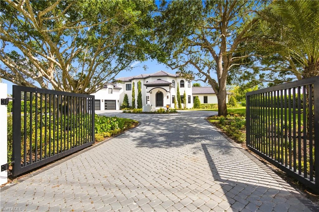 This completely remodeled contemporary home sits on 1.32 acres in Naples’ highly desirable Pine Ridge Estates. A dramatic black-and-white stone foyer with sweeping curved staircase opens to light-filled living and a gourmet kitchen featuring large islands, white marble counters, fluted black bases, and a professional array of appliances. This spectacular residence features a sophisticated primary suite with freestanding tub, multiple guest suites, bonus living room on the 2nd level with wet bar, dual laundries, and a separate, newly constructed guest house with 2 beds, 2 baths, fantastic living area and full kitchen. The home offers a versatile living environment designed to accommodate a variety of lifestyles. Outdoors, enjoy a spacious pool and spa framed by palms, a fully equipped covered outdoor kitchen, inviting covered living areas, and a private pickleball court surrounded by mature landscaping. Exterior lighting beautifully accentuates the home’s architectural features, creating a striking ambiance after dark. Offering over 7,600 air conditioned sq. ft, 7 bedrooms, no HOA, minutes from Naples’ white sand beaches, Waterside Shops, and Mercato. This is a true resort-style, gated Naples estate.