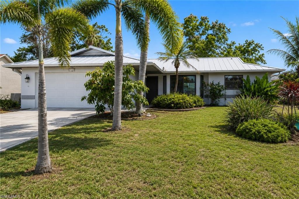 BUYER FINANCING FELL THROUGH, THIS GREAT OPPORTUNITY IS AVAILABLE AGAIN! Welcome to your dream home in the heart of Southwest Cape Coral! This split floorplan 4-bedroom, 2-bathroom residence is perfectly situated in the most desired corner of Cape Coral. On this property you’ll find a variety of mature fruit trees, including a citrus tree, coconut tree, and papaya tree — perfect for enjoying fresh, homegrown fruit right in your backyard! The home boasts a newer METAL roof for durability and longevity. The interior features sleek black granite countertops in the kitchen, a fully tiled living space, a high vaulted ceiling, and pocket sliders to let the breeze flow through the home during those beautiful Florida winter months. City water and sewer is IN and PAID.  Located in a desirable area of Southwest Cape Coral, this home is just minutes away from shopping, dining, and local parks, with easy access to major routes for commuting. Don’t miss out on the chance to own this beautifully updated, move-in ready home with exceptional outdoor space. Schedule your showing today!