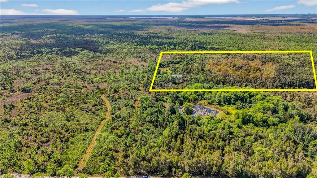 Discover the perfect opportunity to completely unplug and reconnect with nature on this rare 20-acre retreat parcel located in the quiet estates area of Naples. Ideal for those seeking privacy, tranquility, and an authentic off-grid lifestyle, this expansive property offers endless potential for outdoor enthusiasts, hobbyists, and anyone dreaming of their own natural sanctuary.

A sturdy Quonset hut serves as a versatile shelter for storing equipment, parking a vehicle, setting up a comfortable basecamp, or simply relaxing after a day of exploring. With ample room for an RV, fire pit setup, or outdoor gathering spaces, the land invites you to create your own rustic escape.

Because this property is truly off-grid, there is no electricity or running water—a perfect blank canvas for those who prefer self-sufficient living through generators, solar options, or other sustainable alternatives. The current owners have lovingly used this parcel over the years as a peaceful getaway, enjoying the quiet moments and the abundant wildlife that frequent the area. Deer, turkey, and wild hogs have all been captured on the property’s cameras, showcasing the natural beauty that surrounds you.

Whether you're looking for a weekend retreat, a private recreational haven, or the chance to design an eco-friendly living experience, this unique property offers unmatched serenity and space to breathe. Escape the noise, embrace the outdoors, and make this untouched Naples acreage your personal refuge.