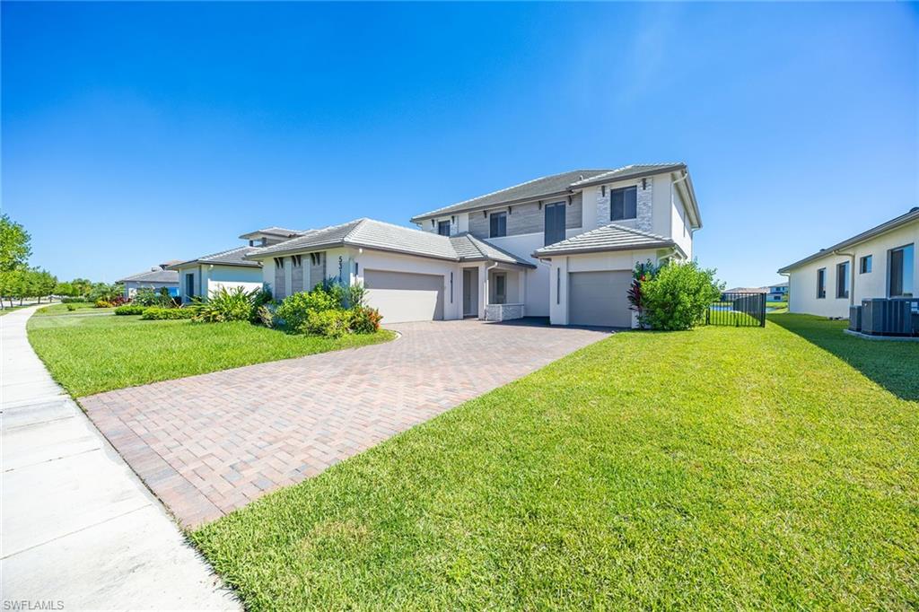 Experience elevated lakefront living in the heart of Ave Maria. This stunning newer two-story residence offers four bedrooms plus den, 3.5 baths and spacious upstairs loft, a three-car garage and desirable southeastern exposure overlooking tranquil lake views. Thoughtfully designed with sophisticated modern finishes, custom designer lighting, marble finishes, wood-plank flooring, impact windows, motorized electric shades and a striking fireplace in the primary suite with exceptional attention to detail. The expansive upstairs loft provides a versatile entertainment retreat for many uses. A fenced backyard enhances the outdoor living experience, creating a wonderful setting to relax and enjoy the picturesque waterfront surroundings. Additional highlights include a tankless water heater and contemporary architectural details throughout. Beyond the home, discover the extraordinary lifestyle of Ave Maria, one of Southwest Florida's most vibrant planned communities. Residents enjoy an impressive collection of recreational amenities, including a resort-style water park with swimming pools, waterslides and a splash area, a state-of-the-art fitness center, tennis, pickleball and bocce courts, basketball and sports fields, playgrounds, dog parks, and scenic recreational and biking trails. Golf enthusiasts will appreciate the community's two golf courses, Panther Run and The National, with access subject to applicable membership requirements. At the heart of the community, Ave Maria's charming Town Center offers restaurants, cafés, boutique shopping, a Publix supermarket, and a lively calendar of community events, festivals and entertainment. Combining refined modern living, beautiful lakefront surroundings, and an exceptional array of lifestyle amenities, this remarkable residence offers an opportunity to enjoy the best of Ave Maria.