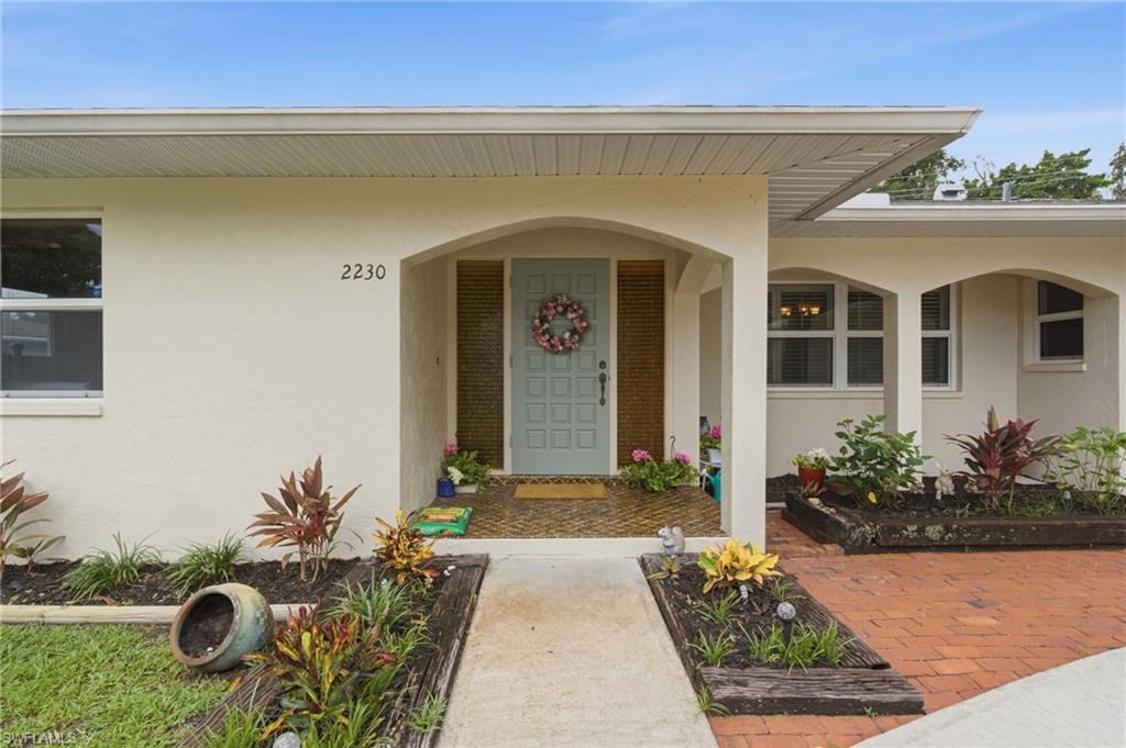 Tucked away at the end of the street on an oversized corner lot, this 3-bedroom plus den, 2-bath home offers a rare and versatile floor plan with plenty of space inside and out. A circular driveway, mature oak tree, and lush landscaping create an inviting approach, while the oversized one-car garage provides additional workspace with air conditioning, a workbench, and laundry area. Inside, the home features hardwood flooring throughout the main living areas and bedrooms, distinctive bay windows, an updated kitchen with refreshed cabinetry and countertops, matching stainless steel LG appliances, and updated bathrooms. The separate den provides valuable flexibility for a home office, guest space, playroom, or additional living area. Additional features include impact windows, a roof replaced in 2019, and an HVAC system replaced in 2016. Out back, the screened patio overlooks a fenced yard surrounded by established landscaping and fruit trees, including starfruit, lychee, and avocado. A storage shed provides additional space and flexibility. Located in the Fort Myers Villas and outside of a designated flood zone, the home offers convenient access to Bell Tower and the surrounding shopping, dining, entertainment, schools, medical facilities, and everyday conveniences of South Fort Myers. With its uncommon floor plan, oversized corner lot, dead-end setting, mature landscaping, and combination of updates and functional spaces, this home offers a distinctive blend of space, character, location, and versatility that's difficult to find.