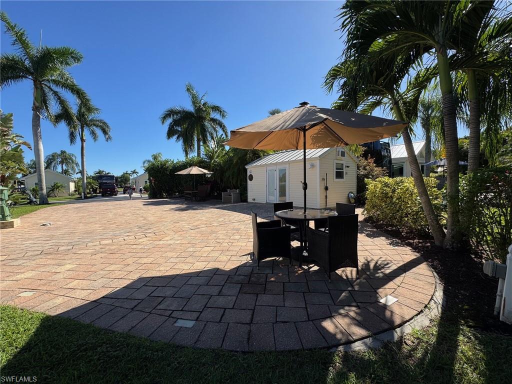 Your Private Slice of Paradise Welcome to Lot 36 at RiverBend Motorcoach Resort, where laid-back luxury, lush privacy, and waterfront Florida living come together beautifully along the Caloosahatchee River. Fully paved and  for outdoor living, this inviting lot features a spacious back patio and lanai surrounded by towering, lush hedges that create a private tropical retreat. There’s plenty of room to gather, dine, relax, and simply enjoy the Florida sunshine. Enjoy dining table beneath a umbrella, with a second shaded table for four and a comfortable lounger ready for those warm, lazy afternoons. The cozy light-blue coach house adds even more comfort and functionality. Inside, you'll find wood-look flooring, a small kitchenette with refrigerator, workspace, a bathroom with shower, and a washer and dryer, everything you need for effortless extended stays. Just steps away, the Creations Clubhouse offers a bright, welcoming space for painting, crafting, and creative gatherings, with beautiful views of tranquil Welcome Lake through its surrounding windows. And then there’s RiverBend itself.
Set along the scenic banks of the Caloosahatchee River, RiverBend Motorcoach Resort is where every day feels a little more like vacation. Watch spectacular sunsets, launch your boat from the private ramp, spend the afternoon poolside, or challenge friends to a game on one of eight pickleball courts. Enjoy bocce, shuffleboard, seasonal activities, and plenty of opportunities to connect with neighbors and friends. The River Clubhouse offers stunning river views and a relaxing place to gather, while the Pool Clubhouse features a resort-style pool, hot tubs, and a lively cabana bar. With a private boat ramp, pet-friendly atmosphere, beautiful amenities, and a welcoming community, RiverBend isn't simply a place to park your coach, it’s a lifestyle. Investment opportunity awaits! Ask the listing agent about the 2026–2027 rental dates and income potential. Owner financing available.
Come discover why Lot 36 could be your perfect place to park, play, relax, and call RiverBend home.